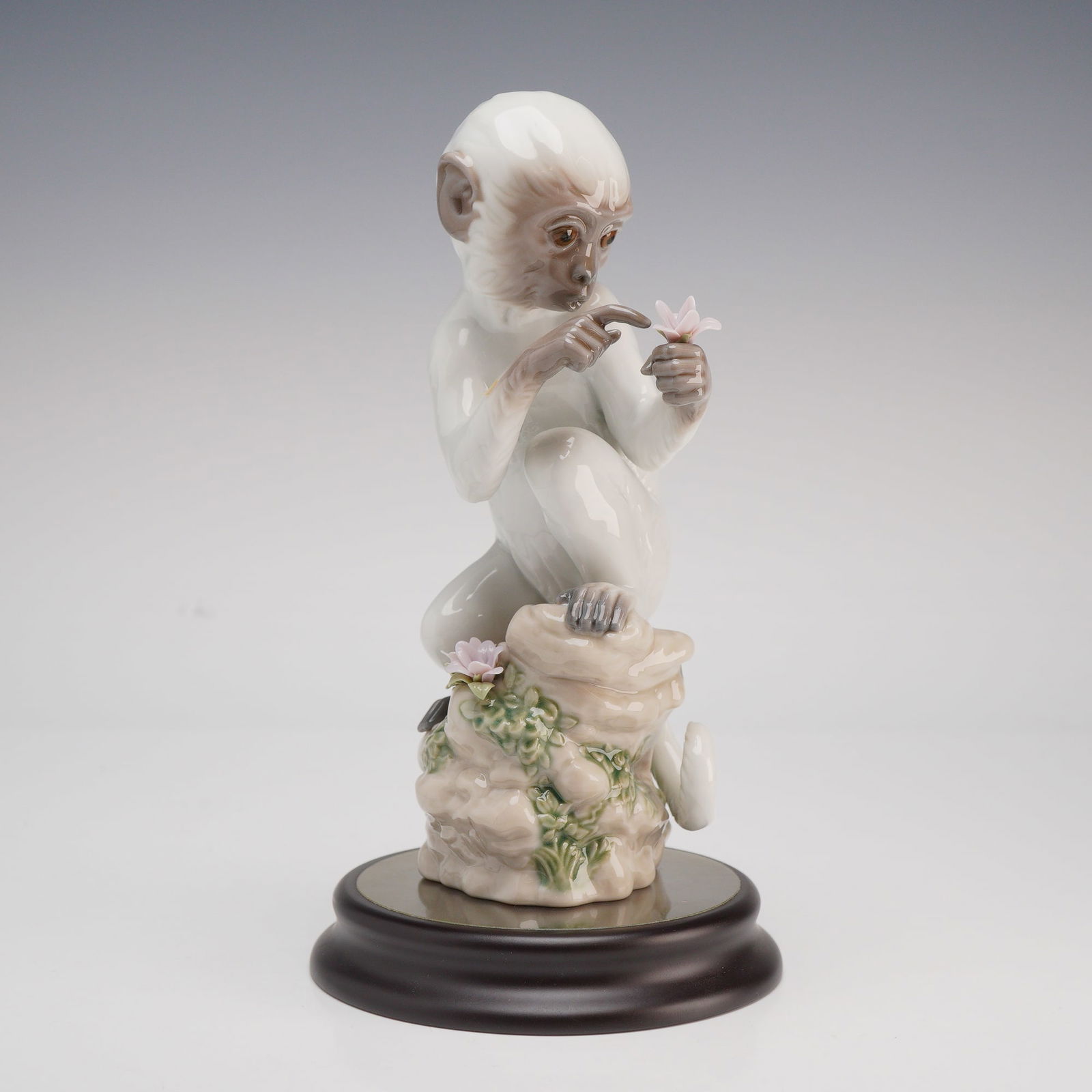 Lladro Porcelain Chinese Zodiac Figurine, The Monkey 1006962: This Lladro glazed porcelain figurine, titled The Monkey (model number 6962), is part of the Chinese Zodiac collection representing the Year of the Monkey. The piece depicts a seated monkey perched up