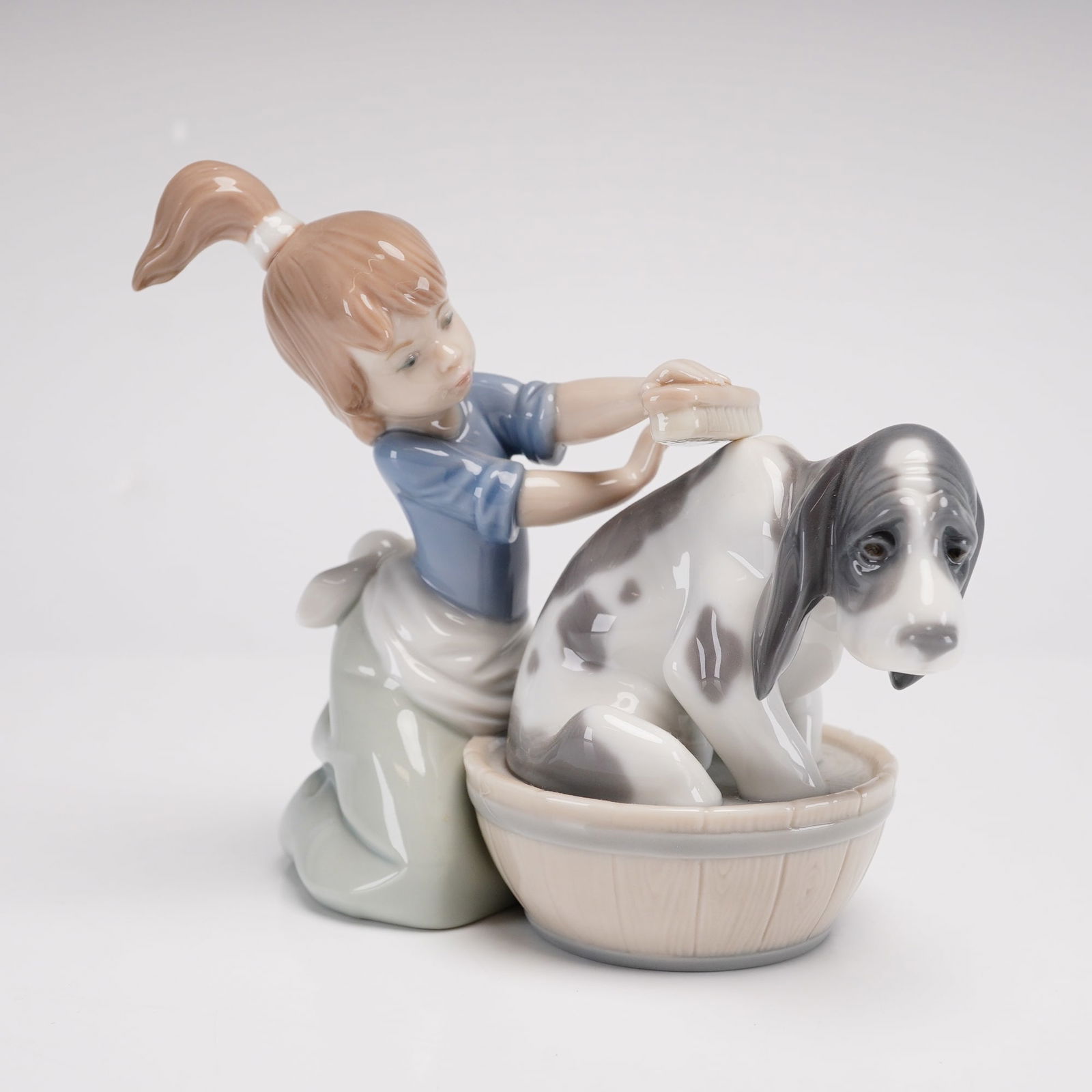 Lladro Porcelain Figurine, Bashful Bather 1005455: This fine glazed porcelain figurine by Lladro is titled Bashful Bather, model number 5455. Designed by sculptor Juan Huerta and first issued in 1988, the piece depicts a young girl with her hair in a