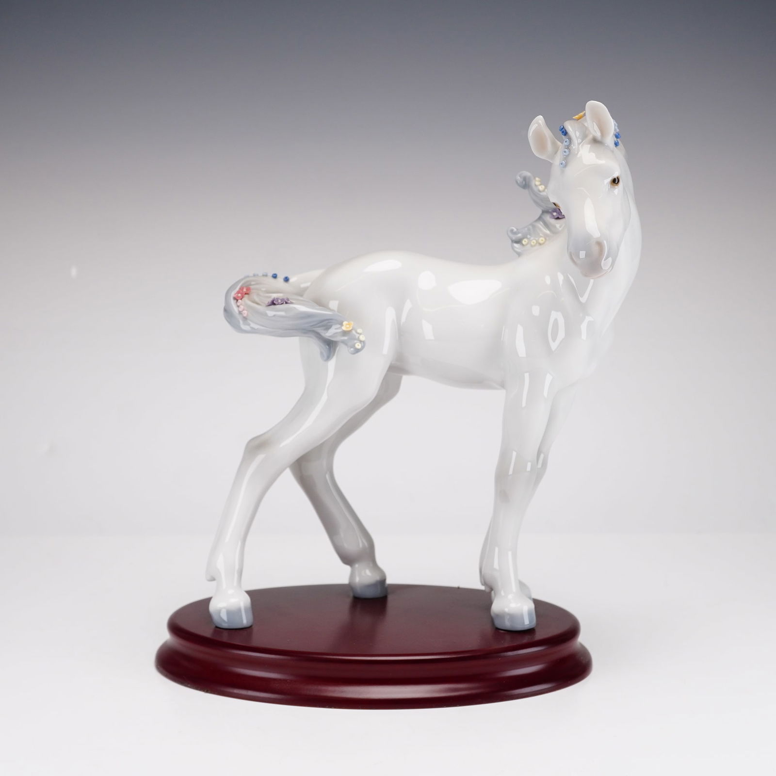 Lladro Porcelain Zodiac Collection Figurine, The Horse 1006827: This fine glazed porcelain figurine by Lladro is from the Lladro Zodiac Collection representing the "Year of the Horse." The piece features a standing foal with a glossy white glaze and soft gray acce
