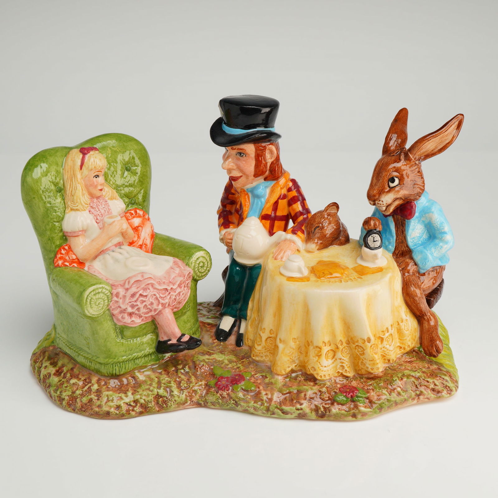 Beswick Ware Figural Group The Mad Hatter's Tea Party: A glazed earthenware figural grouping manufactured by Beswick Ware under the Royal Doulton copyright. The tableau, titled 'The Mad Hatter's Tea Party,' model number LC 1, depicts four characters from