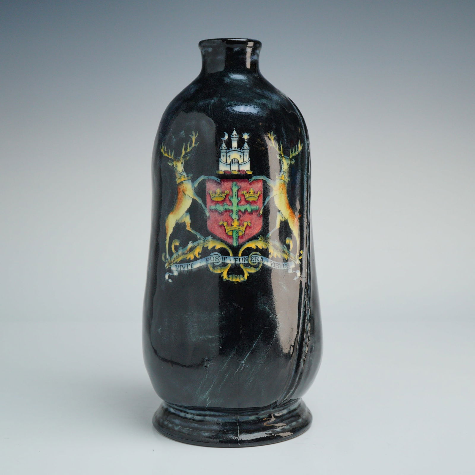 Royal Doulton Leatherware Jug for Skinner and Rook Nottingham: The vessel features a bulbous form with an integral handle and is finished in a dark, mottled deep brown to black glaze. The front is decorated with a transfer-printed polychrome heraldic coat of
