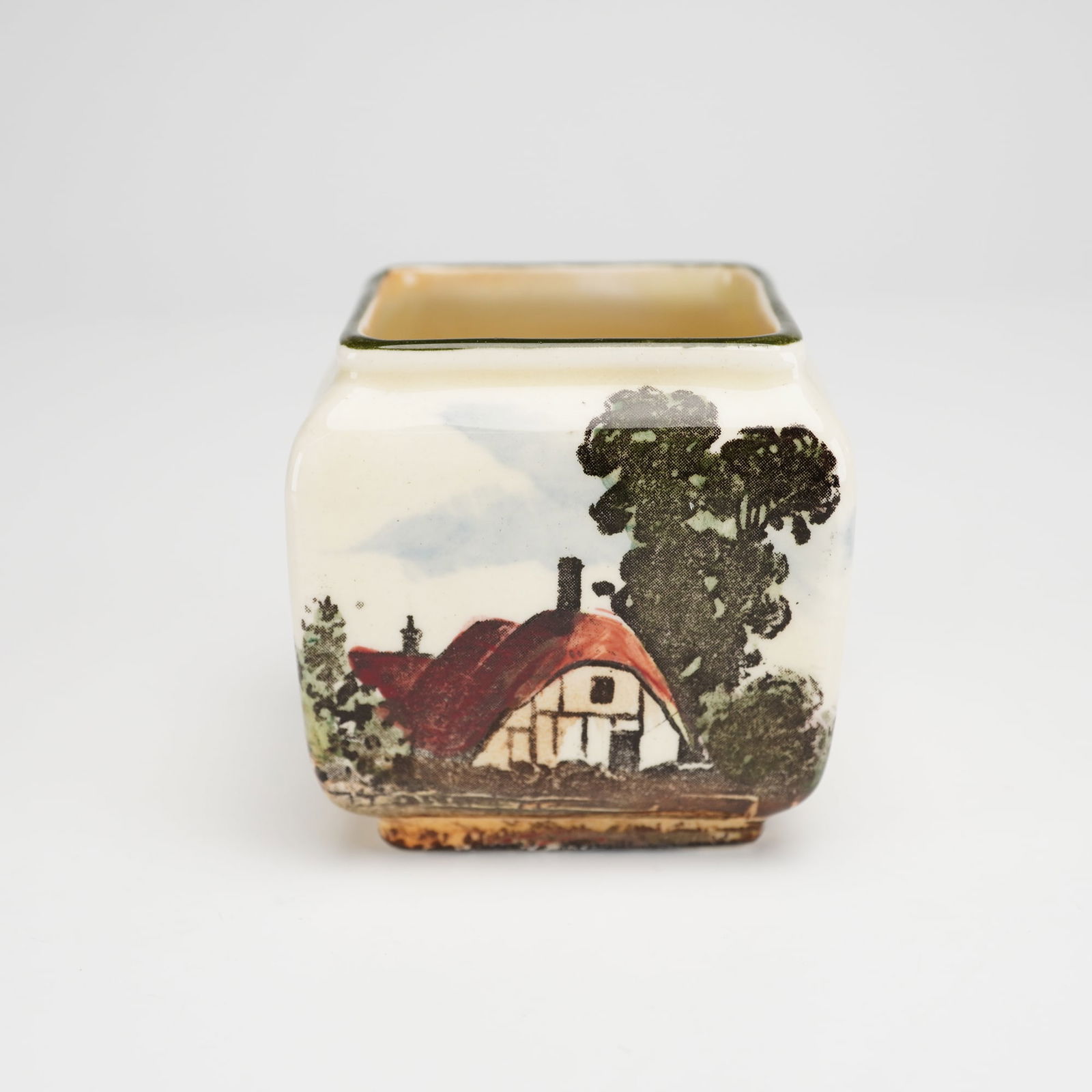 Royal Doulton Series Ware Rustic England Square Mini Vase: A Royal Doulton Series Ware mini vase of square form with rounded shoulders, decorated in the Rustic England pattern. The ceramic vessel features a continuous transfer-printed pastoral landscape