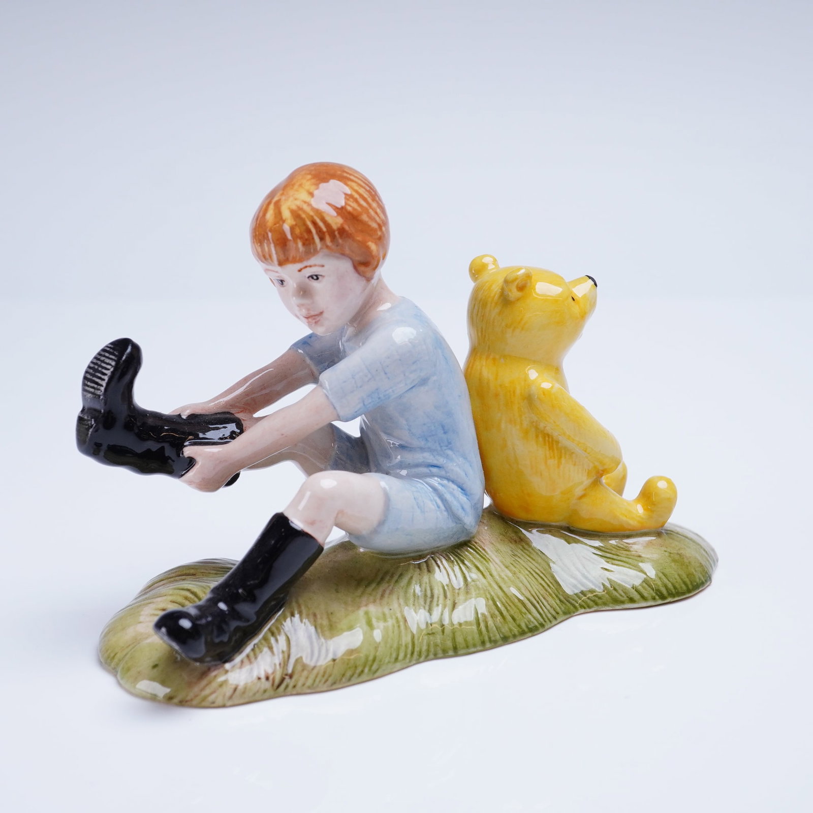 Royal Doulton Winnie the Pooh Figurine, Christopher Robin and Pooh WP10: A glazed porcelain figurine from the Royal Doulton Winnie the Pooh Collection, titled Christopher Robin and Pooh, model number WP 10. The figure depicts Christopher Robin, rendered with reddish-brown