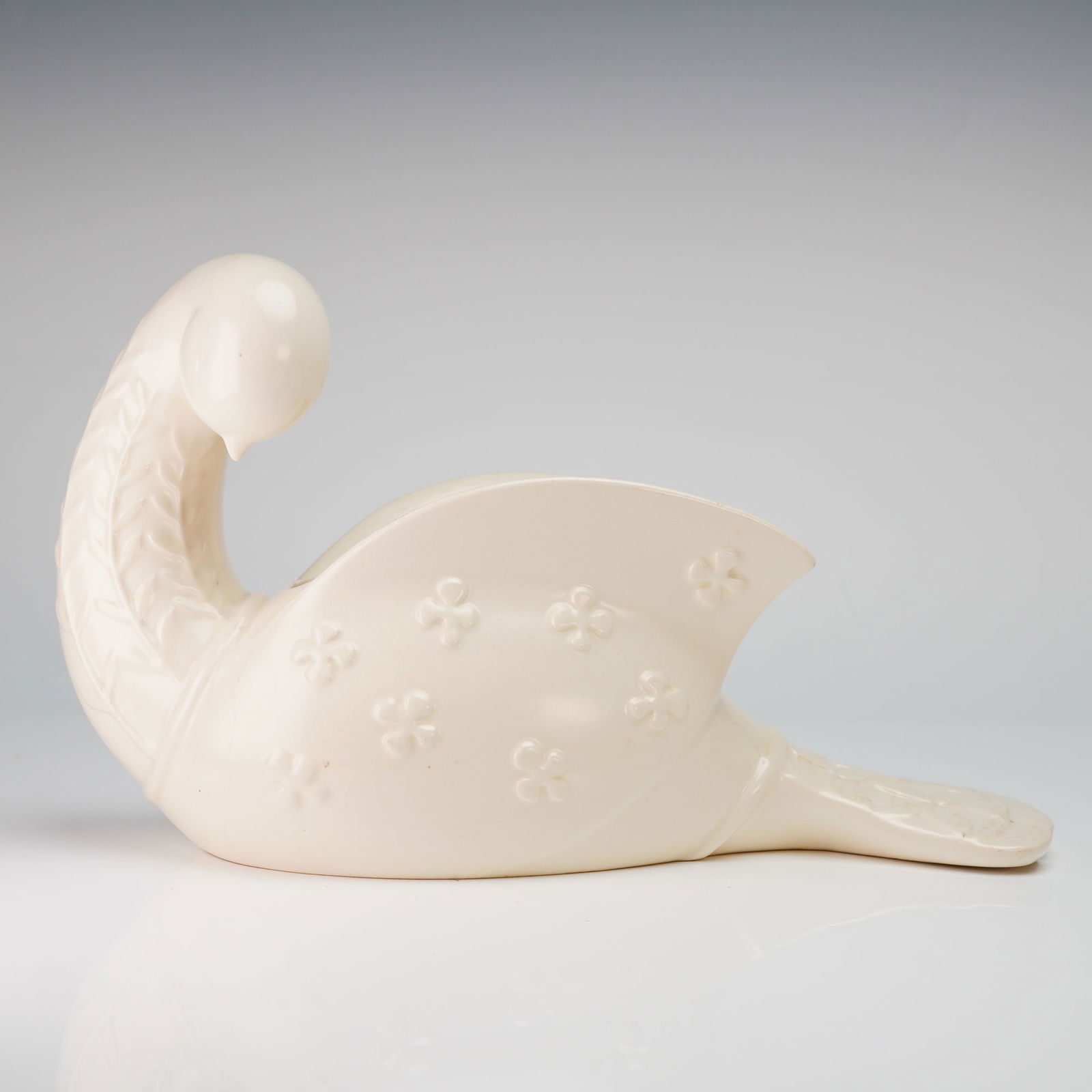 Beswick by Kathi Urbach Porcelain Dove Planter: This glazed ceramic vessel is formed as a stylized bird, often identified as a peace dove, with its head turned back toward a central opening in the upper body. The piece is finished in an off-white