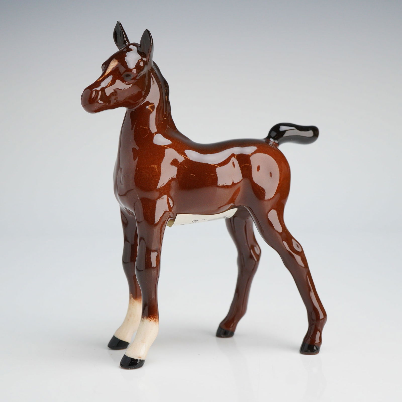 John Beswick Ceramic Foal Figurine with Original Box: A John Beswick Figurine of a Foal, confirmed to be ceramic, featuring glossy brown, black, and white coloring, including the original green box marked John Beswick. Dimensions3.50"L x 1.50"W x 4.50"H
