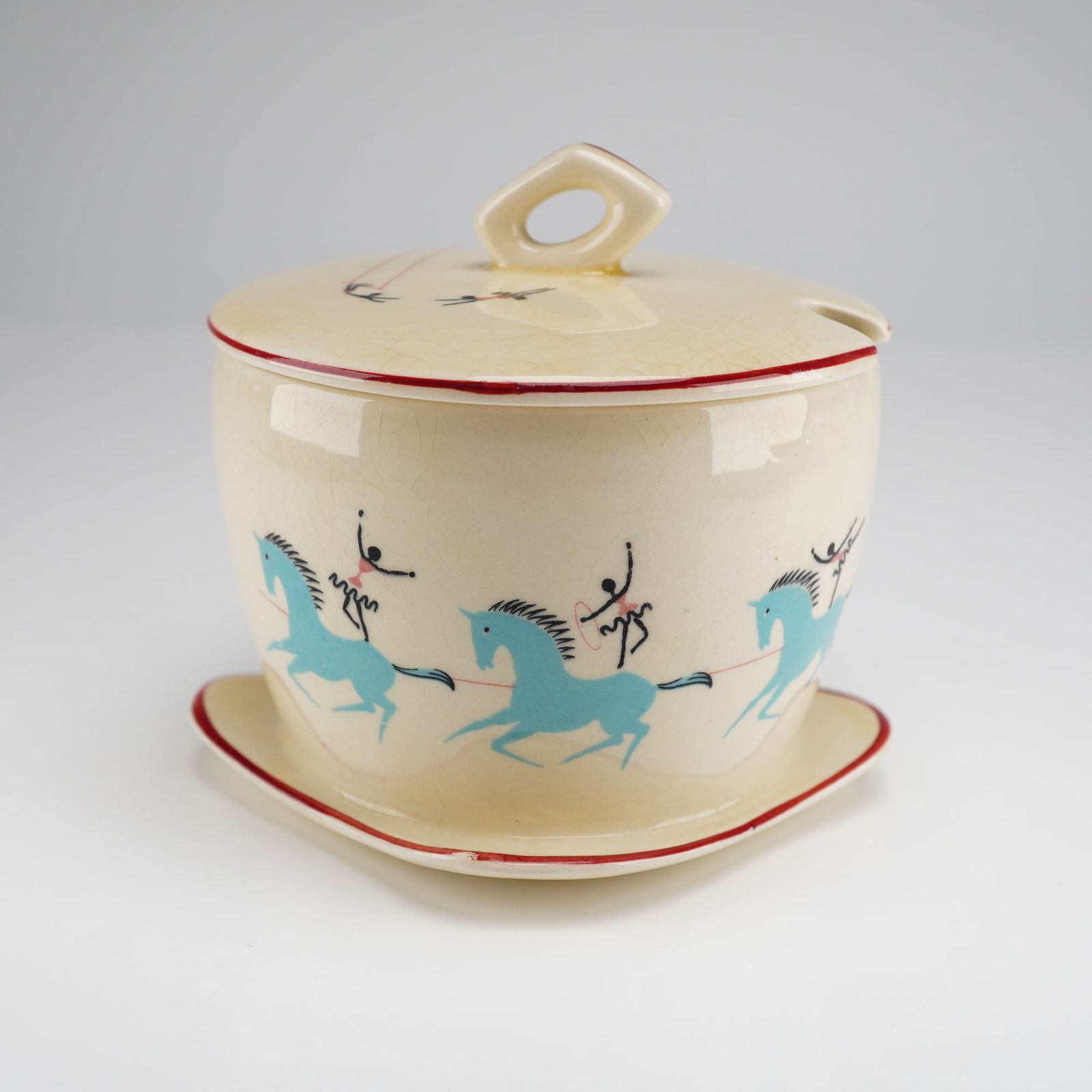 A Beswick Pottery Circus Pattern Preserve Pot: A Beswick pottery preserve pot in the Circus pattern, dating to the 1950s. This ceramic condiment pot features a cream-glazed body and lid decorated with hand-painted underglaze designs of stylized li