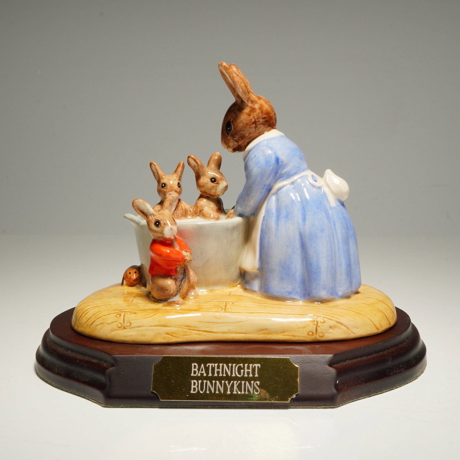 Royal Doulton Bunnykins Figurine, Bath Night DB241 with Base: A Royal Doulton Bunnykins glazed porcelain figurine tableau titled Bath Night, model number DB241. The piece is hand-made and hand-decorated, depicting a mother rabbit in a blue dress and white apron