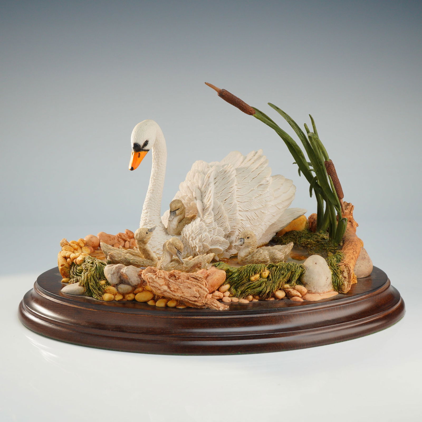 Country Artists Swan and Cygnets Figurine, First Outing: A hand-painted wildlife sculpture titled First Outing by Country Artists, model number CA 714. The piece depicts a white swan with four cygnets situated in a naturalistic pond environment featuring bu