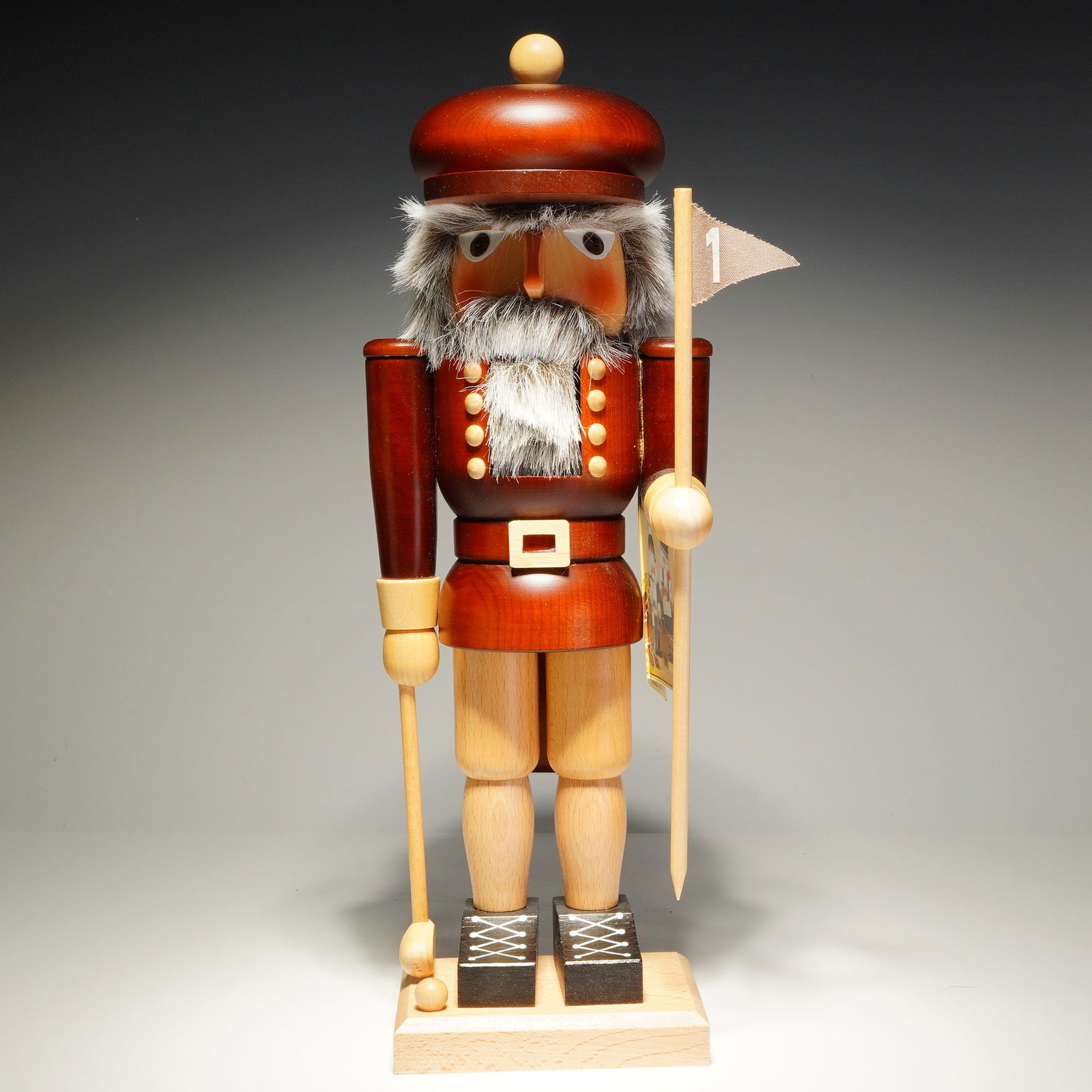Christian Ulbricht Natural Wood Nutcracker, Golfer: Handcrafted wooden nutcracker is constructed from turned and carved wood, featuring a dark-stained finish on the torso and flat cap, contrasted by natural wood limbs and base. The character is styled
