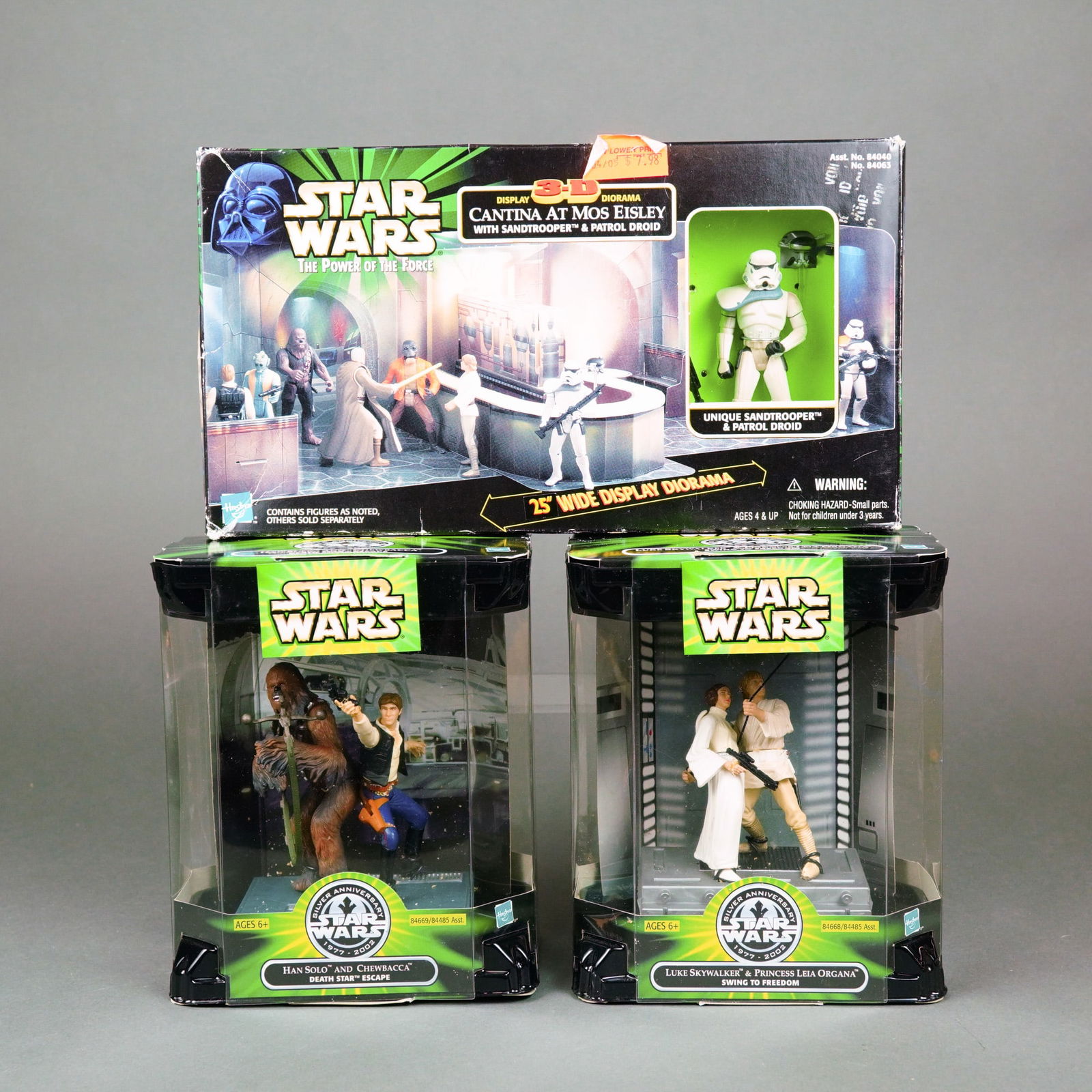 Hasbro Star Wars The Power of the Force and Silver Anniversary Diorama Sets, 1998-2002.: This lot features three collectible Star Wars diorama sets manufactured by Hasbro. The first item is a Star Wars: The Power of the Force 3-D Display Diorama of the Cantina at Mos Eisley, which include