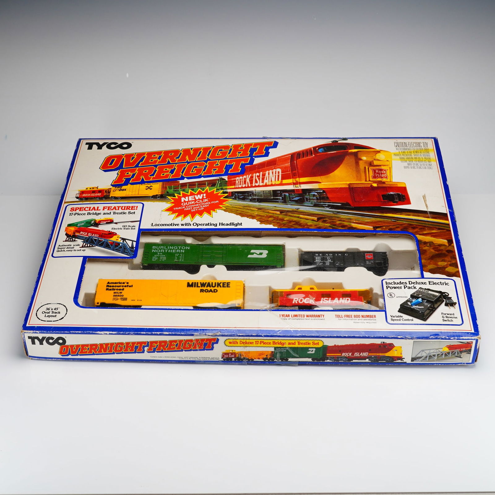 Vintage Tyco HO Scale Overnight Freight Electric Train Set: This Tyco HO scale Overnight Freight electric train set, model number 7412, is housed in its original color-illustrated box. The set as presented includes a collection of freight cars featuring