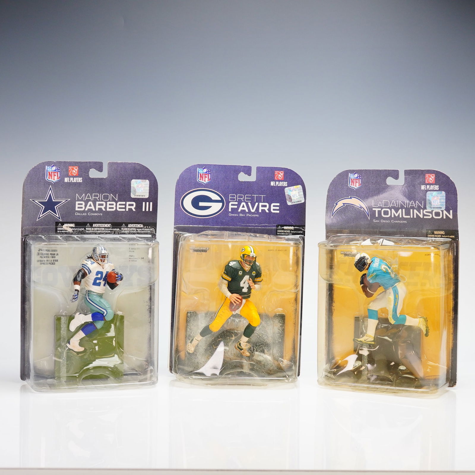 A Trio of McFarlane Toys NFL SportsPicks Action Figures: A trio of McFarlane Toys NFL SportsPicks action figures featuring Marion Barber III of the Dallas Cowboys, Brett Favre of the Green Bay Packers, and LaDainian Tomlinson of the San Diego Chargers.
