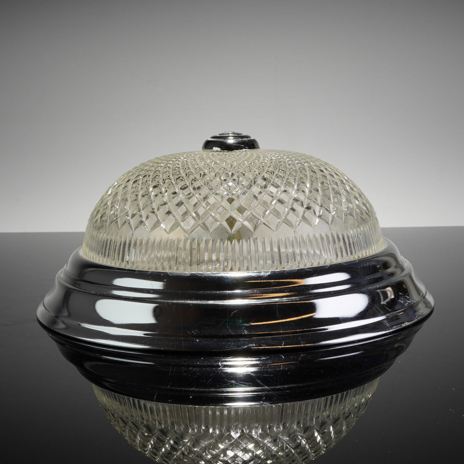 Mid-Century Modern Pressed Glass and Aluminum Flush-Mount Ceiling Light Fixture: Features a polished chrome-plated metal housing and a heavy, clear pressed glass shade. The domed shade features a geometric diamond-quilted pattern with a vertically reeded lower border, accented at