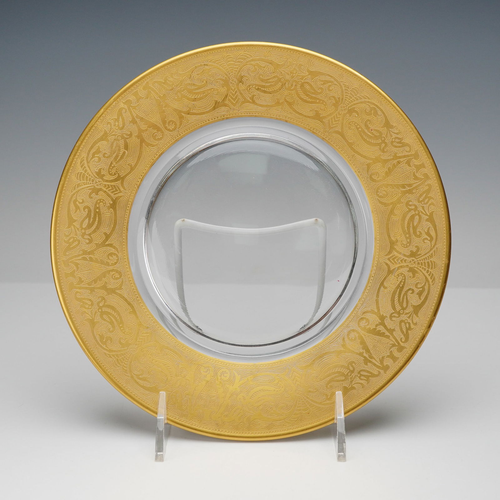Georgian Gold Rimmed Decorative Plate: An elegant decorative plate showcasing a luxurious wide gold rim with intricate neoclassical motifs finely etched in relief, framing a clear glass center. The detailed design features ornate