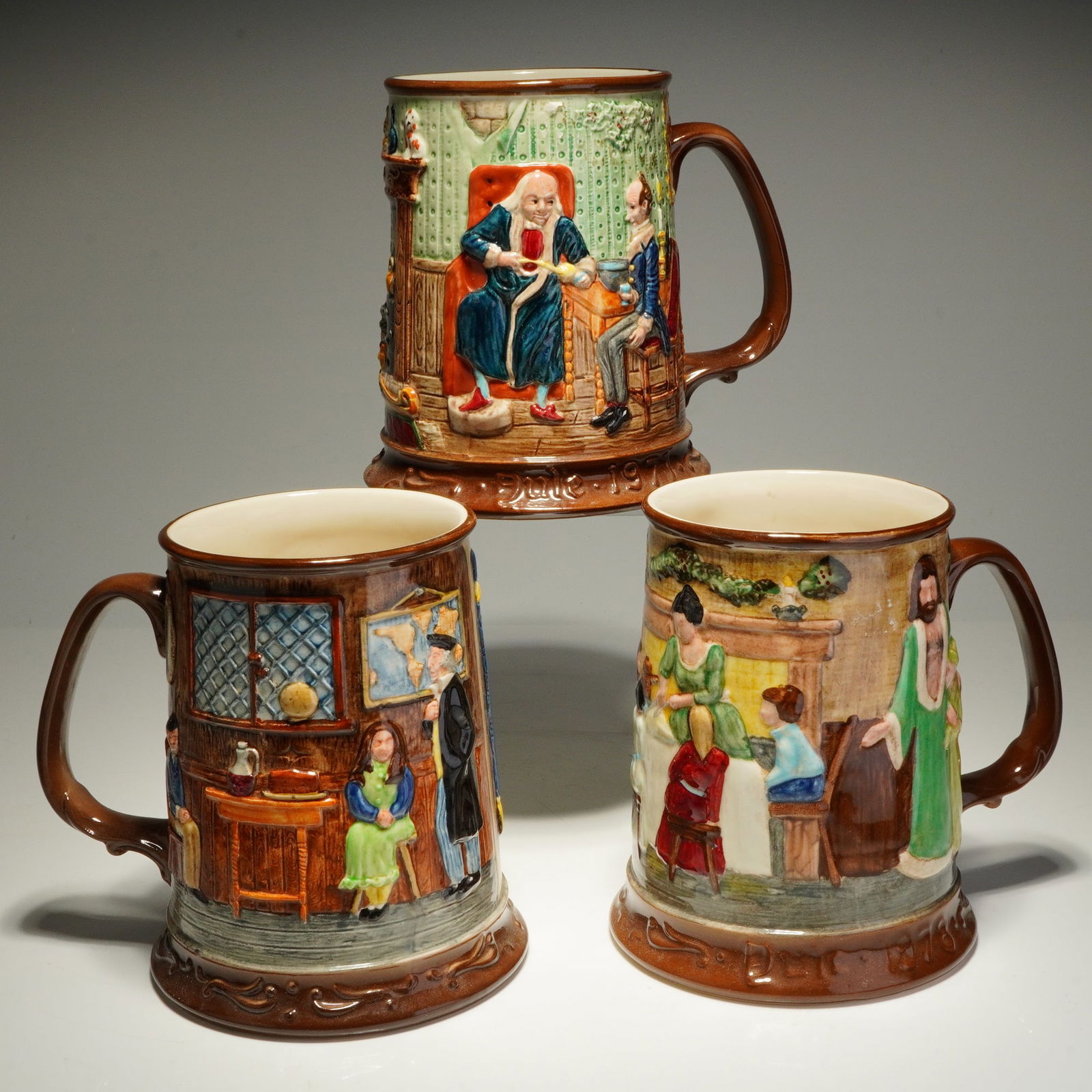 Three Royal Doulton John Beswick Limited Edition A Christmas Carol Tankards: A trio of limited edition relief-molded ceramic tankards produced by John Beswick Ltd. for the Royal Doulton Group under the Collectors International label. These glazed earthenware jugs feature