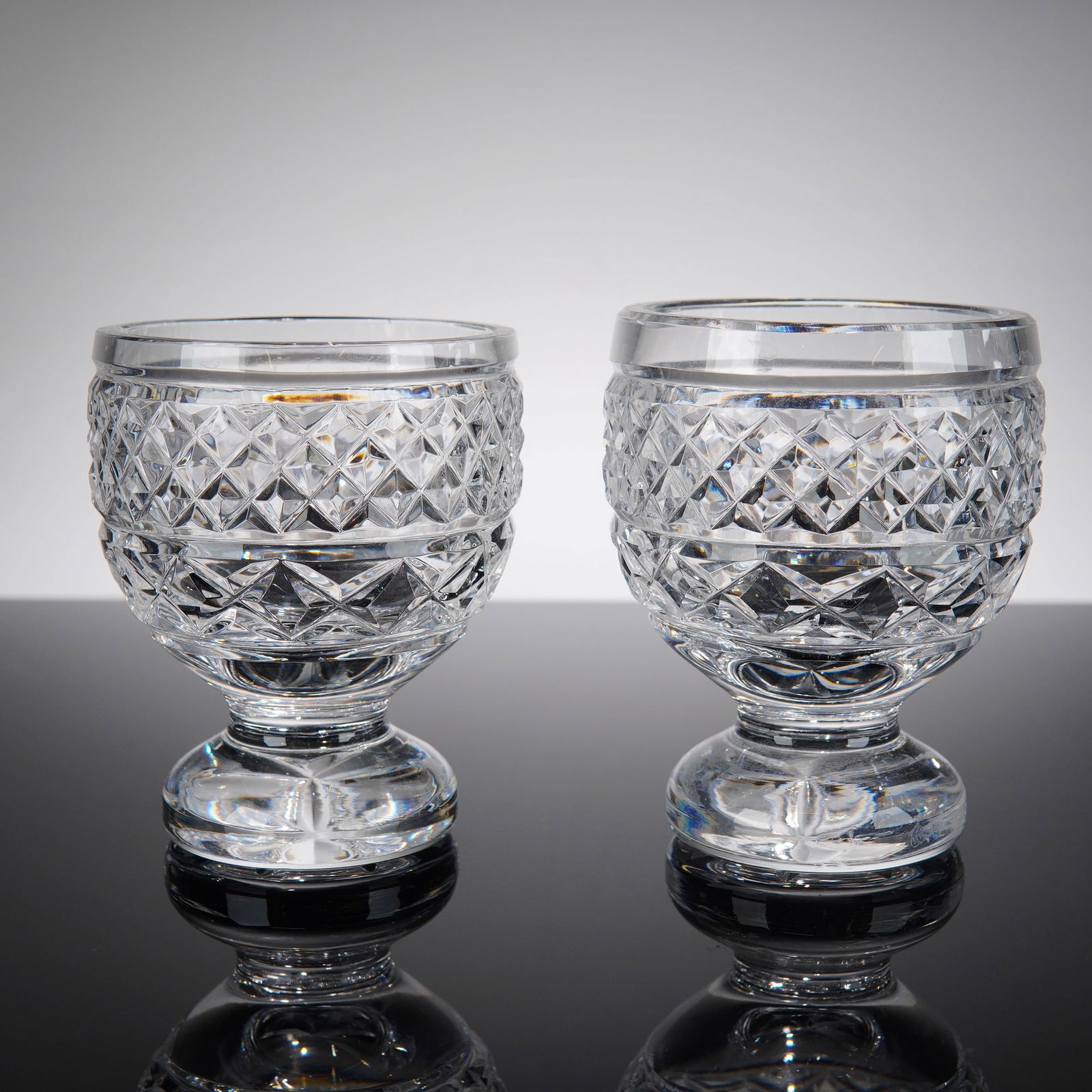 Pair of Waterford Crystal Sorbet Cups: A set of two clear crystal footed dessert bowls, each featuring criss-cross and horizontal cut patterns. Each cup is marked Waterford. Dimensions3.00"W x 3.75"H