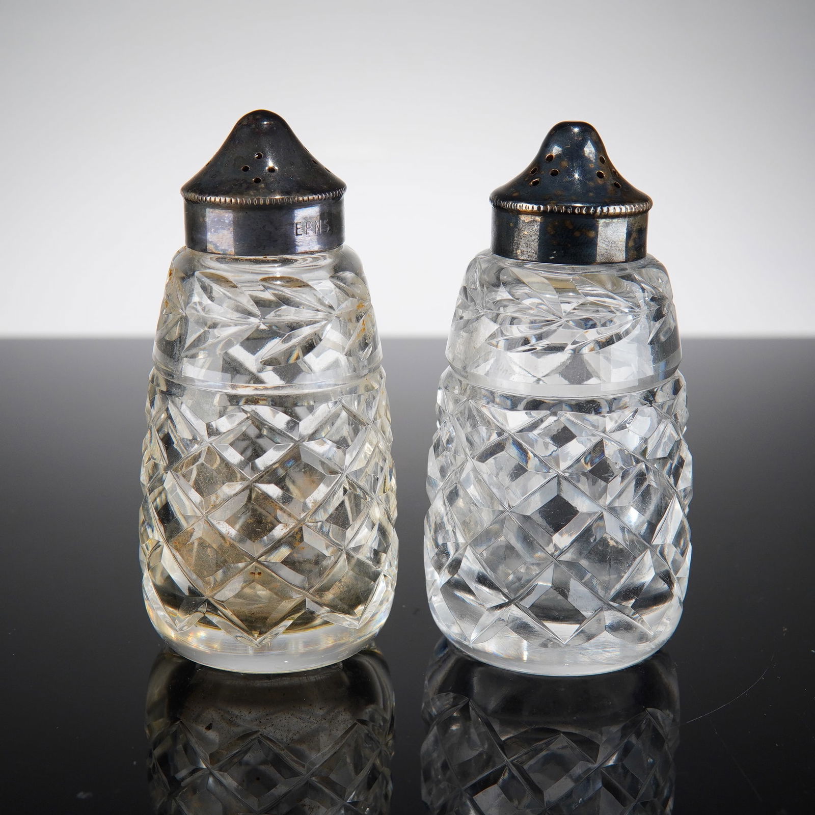 Waterford Glandore Pattern Cut Crystal Salt and Pepper Shakers: This pair of matched salt and pepper shakers is crafted from high-quality lead crystal in the Glandore pattern by Waterford. The design features a traditional deep-cut diamond motif across the body an