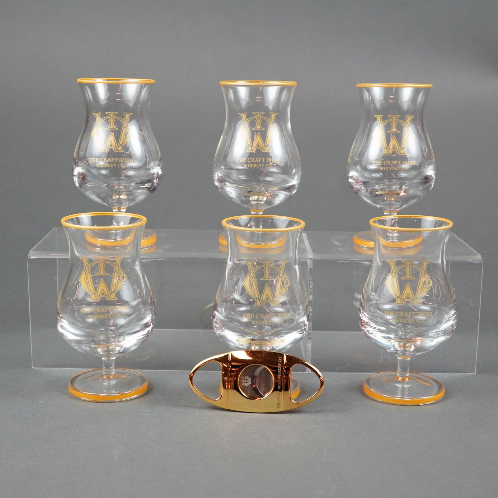 The Craft Irish Whiskey Co. 7pc Branded Glassware and Cigar Cutter Set: This professional 7pc Craft Irish Whiskey glasses and cigar cutter set is produced by The Craft Irish Whiskey Co. The collection consists of six elegant stemmed tasting glasses and one double guilloti