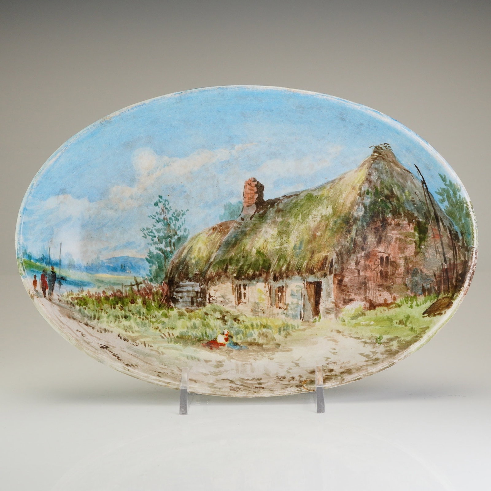 Wedgwood Hand-Painted Creamware Landscape Bowl: This Victorian-era creamware bowl, produced by the renowned Wedgwood factory at Etruria. The oval form serves as a canvas for a detailed, hand-painted polychrome landscape scene. The composition featu