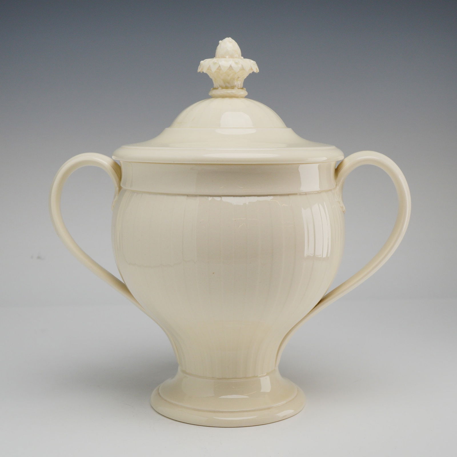 Wedgwood of Etruria & Barlaston Queensware Lidded Two-Handled Jar: Elegant lidded sugar bowl by Wedgwood, marked “Wedgwood of Etruria & Barlaston” on the underside. This refined piece features a classical urn-inspired silhouette with a gently rounded, vertica