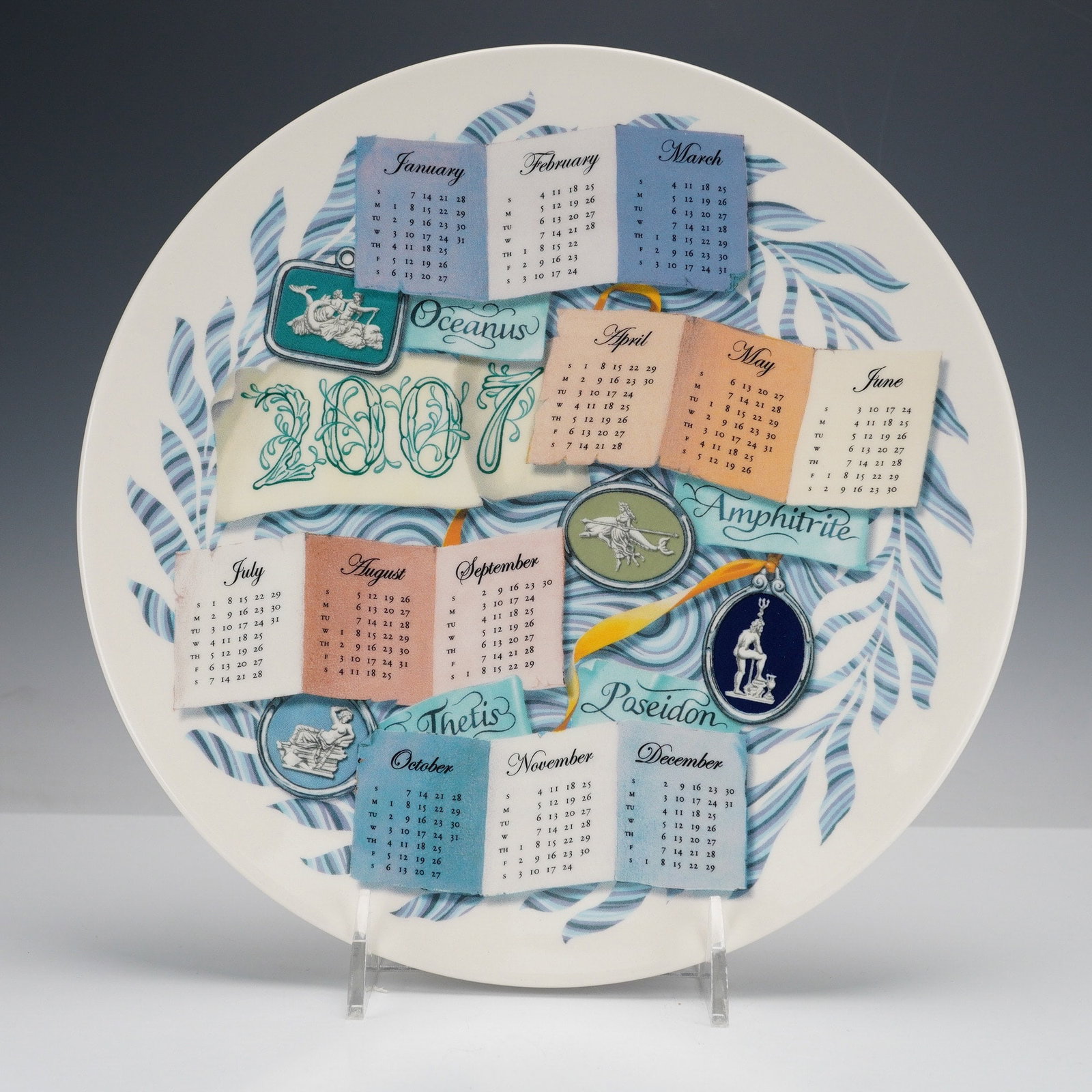 Wedgwood Queensware Calendar The Elements Water' Plate, 2007: A Wedgwood Queen's Ware 'Calendar The Elements Water' plate from 2007, made in England. This round ceramic decorative plate features a complete 2007 calendar on the obverse, with each month represente