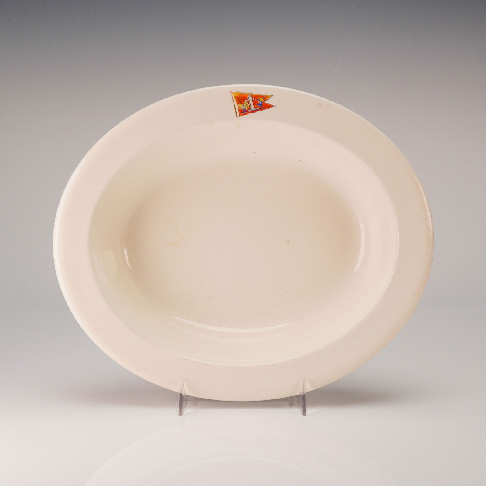 Wedgwood Creamware Oval Serving Bowl w/ Transfer Print: A single Wedgwood Etruria and Barlaston Creamware Oval Bowl, likely dating to the mid-20th century. The earthenware body is finished with a cream glaze. The face of the oval bowl features a small, col