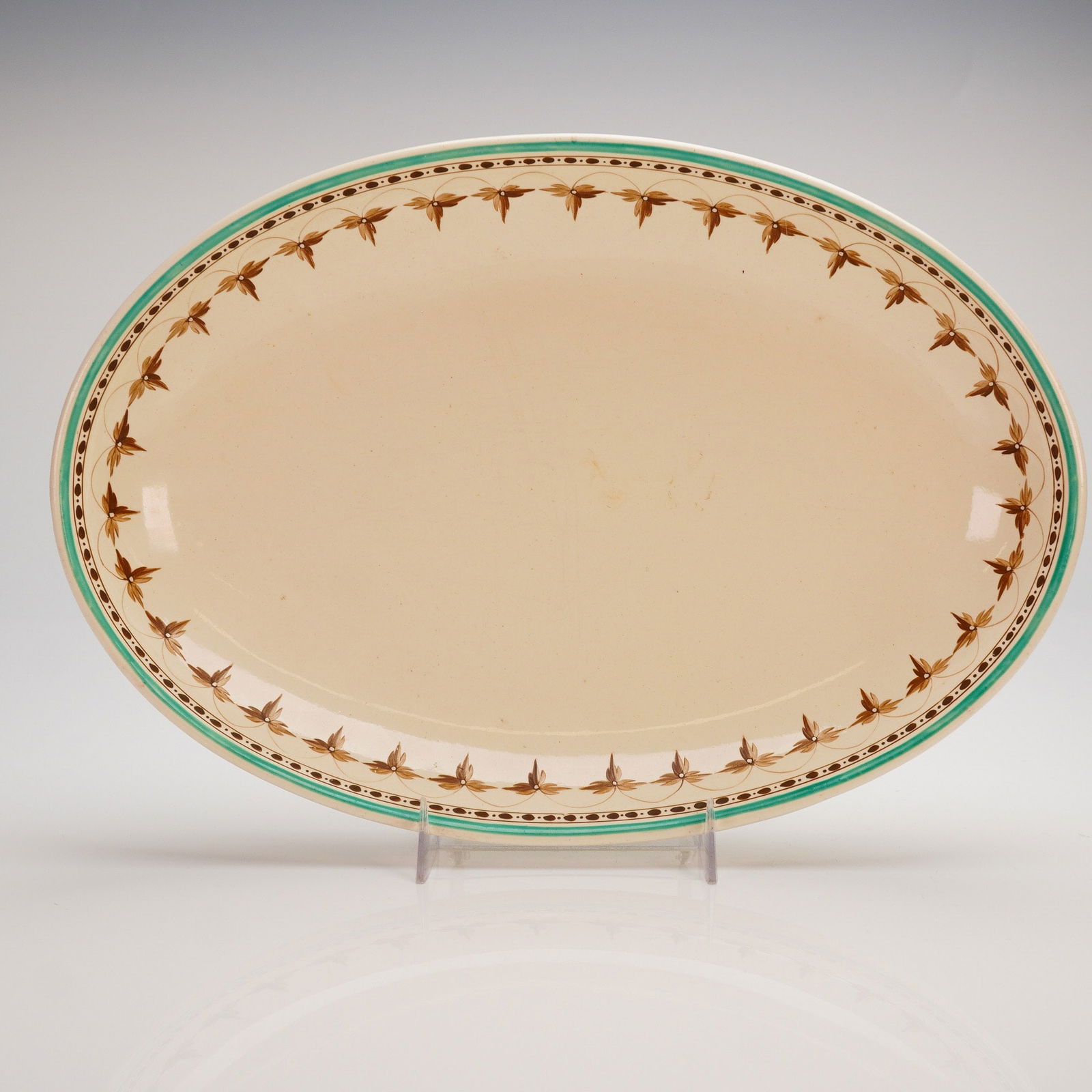 Wedgwood Creamware Oval Serving Platter: A single oval serving platter identified as Wedgwood Creamware, consistent with early 19th-century production. The platter is constructed of earthenware and features a creamy yellow glaze. The rim is