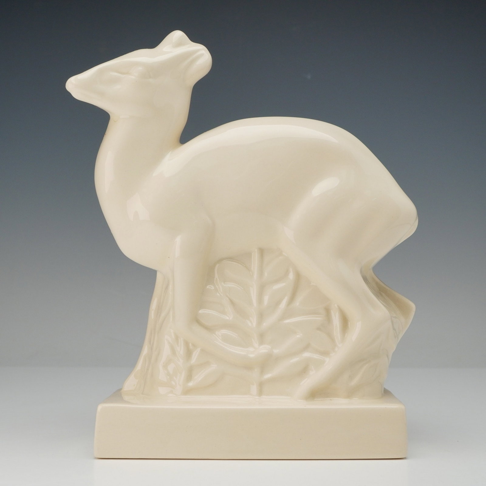Wedgwood Art Deco Duiker Deer Sculpture by John Skeaping: A single glazed ceramic figural sculpture of a standing Duiker Deer, designed by John Skeaping for Wedgwood. The piece is executed in a sleek, streamlined Art Deco or Modernist style, finished in a un