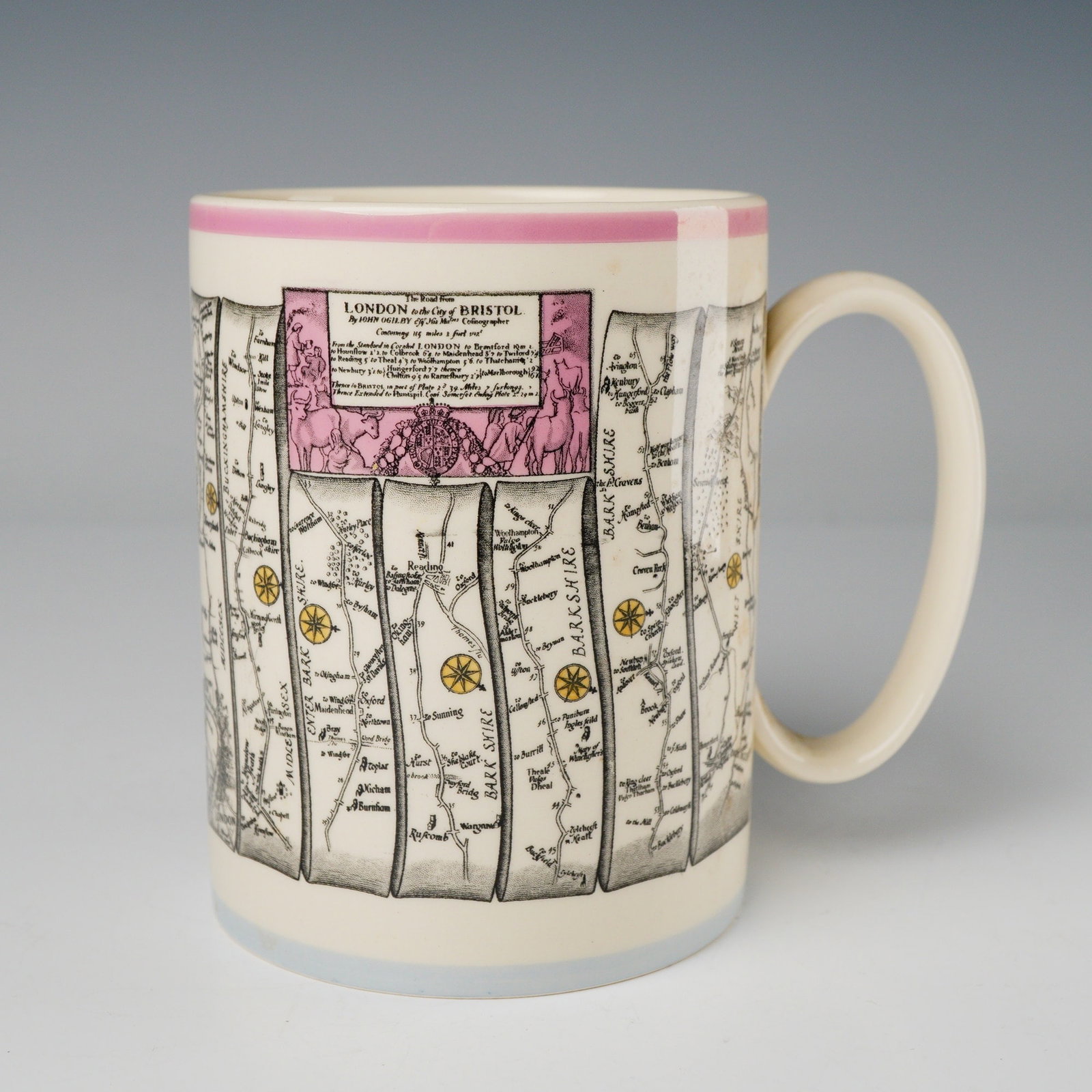 Wedgwood Britannia Series by John Ogilby, London to Bristol: A handled mug produced by Wedgwood, of Etruria & Barlaston, Made in England, featuring the Britannia series decoration in an ecru glaze. The primary decoration is a multi-color transfer print depictin