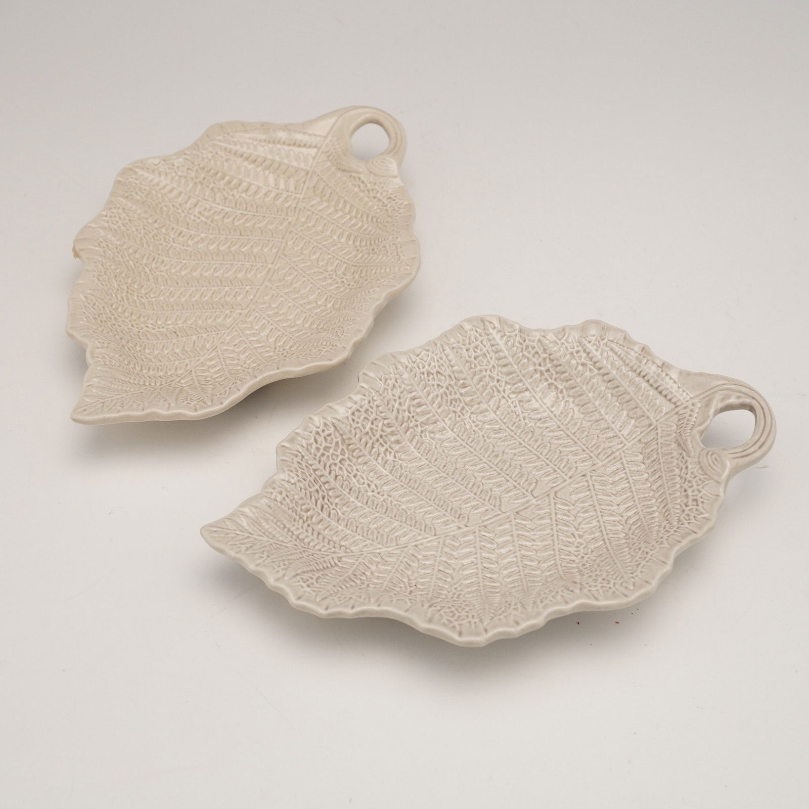 Pair of Wedgwood for Williamsburg Restoration Inc. Ceramic Fern Trays: A pair of ceramic fern trays produced by Wedgwood for Williamsburg Restoration Inc. Each is molded in the naturalistic form of a fern frond with finely impressed textural details and an integrated loo