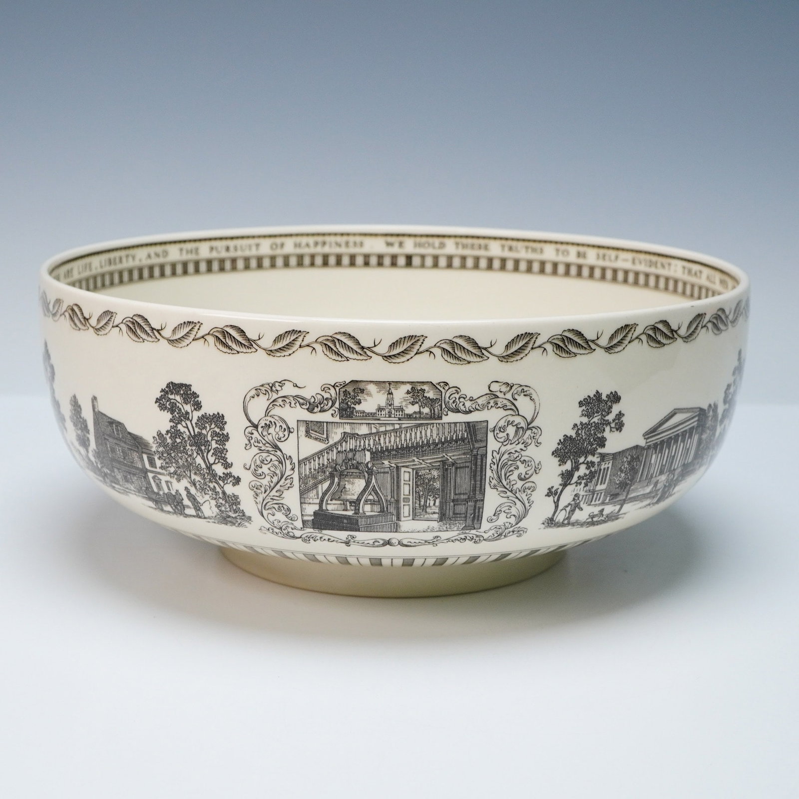 Wedgwood Porcelain 'Liberty Bowl' Philadelphia Commemorative: A Wedgwood 'The Liberty Bowl' Philadelphia commemorative serving bowl, crafted from cream-colored porcelain. The exterior is extensively decorated with sepia transfer-printed vignettes depicting histo
