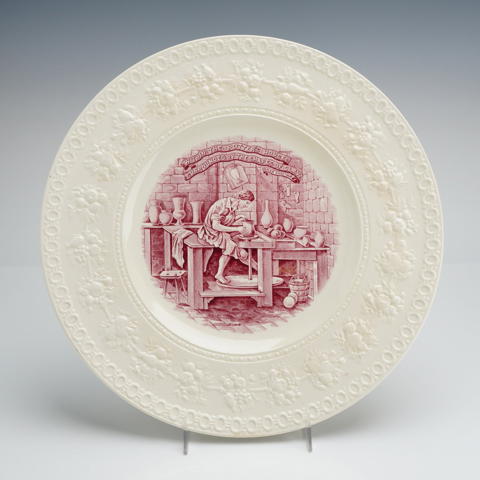 Wedgwood Wellesley The Potter Commemorative Plate: A vintage Wedgwood cream-colored earthenware plate in the Wellesley pattern, featuring an embossed relief border of grapevines and floral motifs. The center well is decorated with a mulberry-colored t