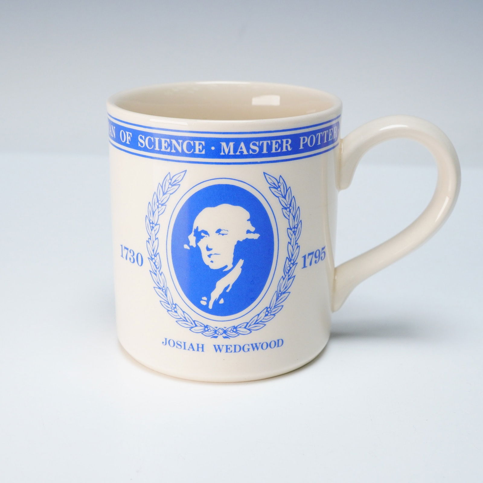 Wedgwood The Arts and Sciences United 1978 London Exhibition Mug: A Wedgwood commemorative mug, produced in 1978 for 'The Arts & Sciences United' exhibition at the Science Museum, London. The cream-colored glazed ceramic mug features blue transfer-printed decoration