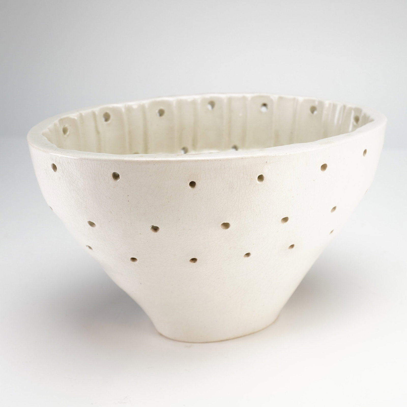 Wedgwood Pottery Cheese Curd Mold: An antique Wedgwood creamware cheese curd mold of oval form with a tapered base. The ceramic body features multiple circular perforations for drainage. The interior wall is designed with a decorative