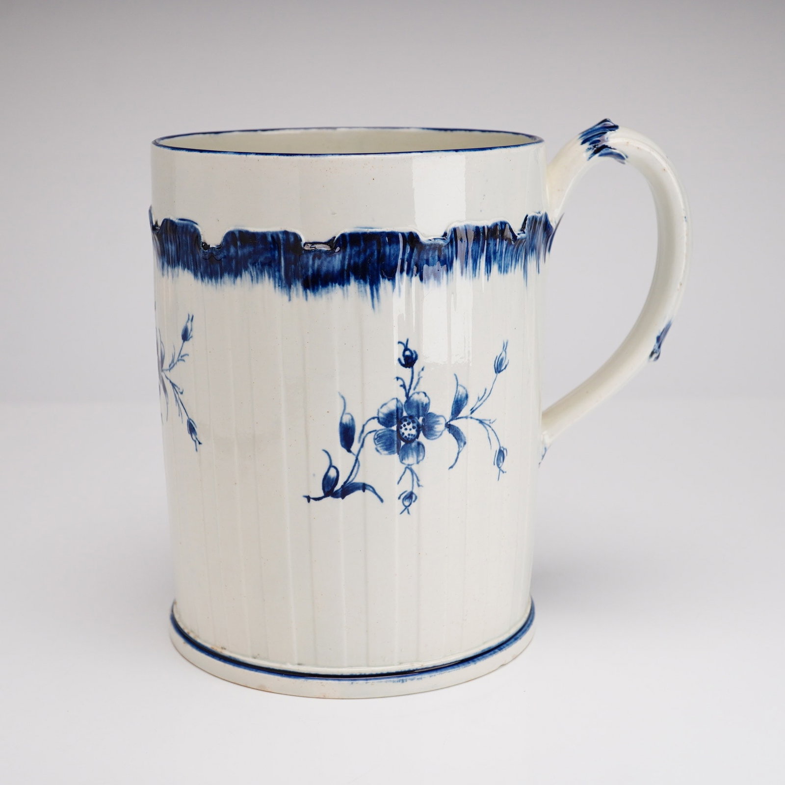 Wedgwood Shell Edge Tankard: A Wedgwood pearlware earthenware tankard dating to the late 18th or early 19th century. The cylindrical body features molded vertical fluting and a simple loop handle. Decoration consists of hand-pain