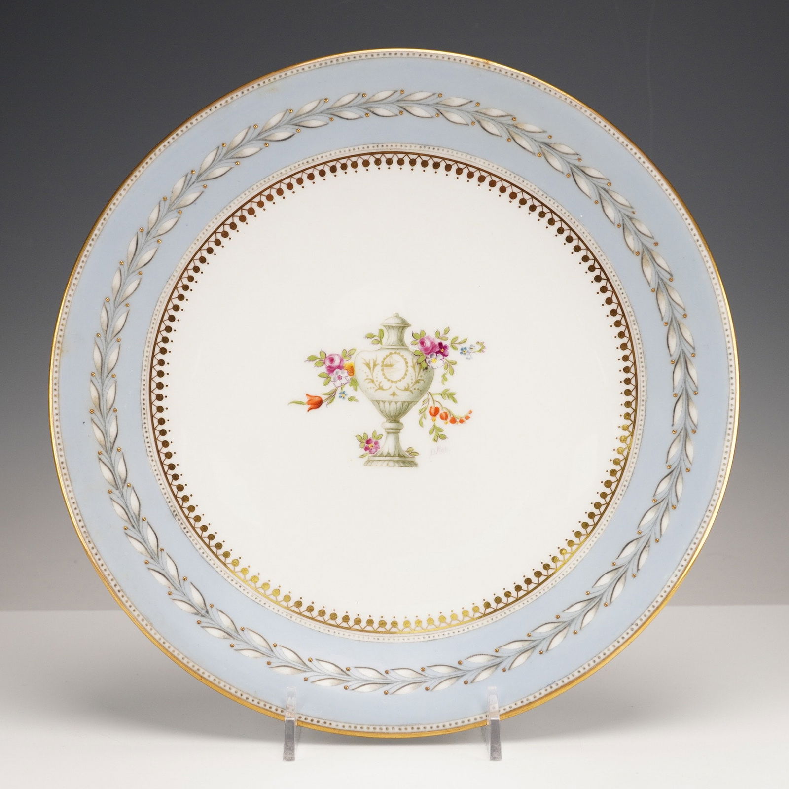 Wedgwood Hand-Painted Cabinet Plate, Urn & Flowers, Signed A. Hall, X7654: A Wedgwood hand-painted cabinet plate, crafted from fine bone china in a Neoclassical revival style. The circular plate features a central white field adorned with a polychrome transfer-printed and ha