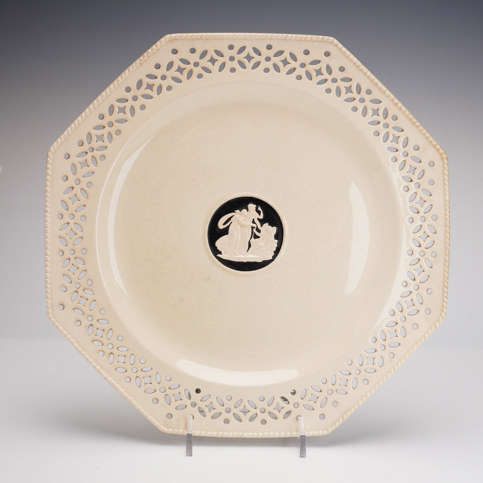 Wedgwood, Neoclassical Reticulated, Octagonal Plate: Manufactured by Wedgwood in their signature Queen's Ware creamware, this octagonal plate features an intricate reticulated border with a geometric and floral motif and a molded beaded rim. The center