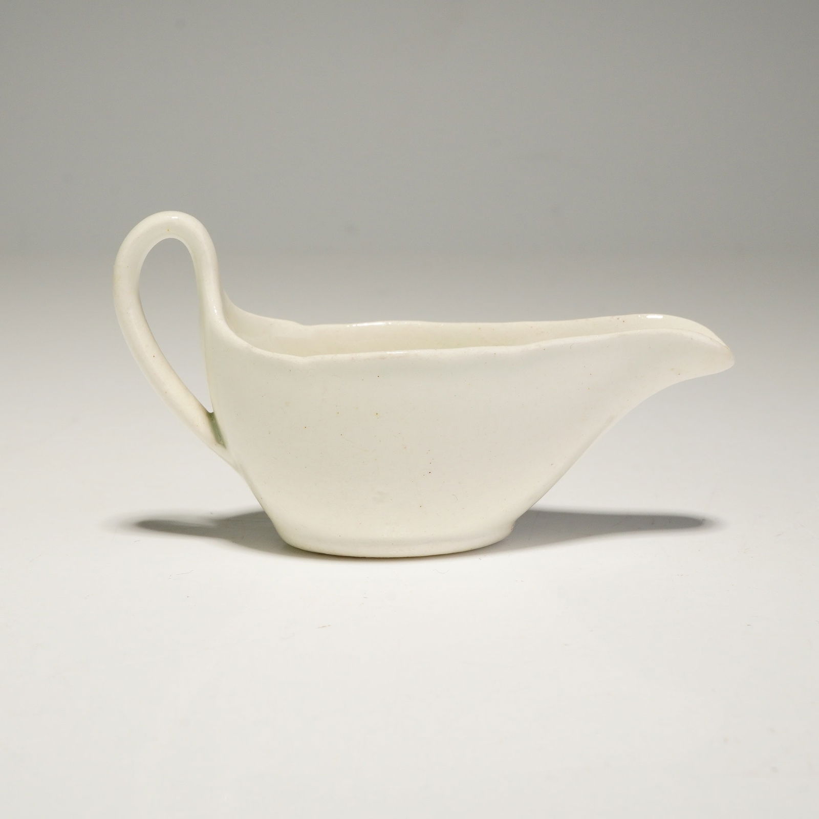 Wedgwood Solar Shape 225 Miniature Pouring Vessel Sauce Boat: A Wedgwood ceramic sauce boat in the Solar pattern, Shape 225. This miniature pouring vessel is constructed with a white matte-glazed finish and features an organic, asymmetrical design. The piece is