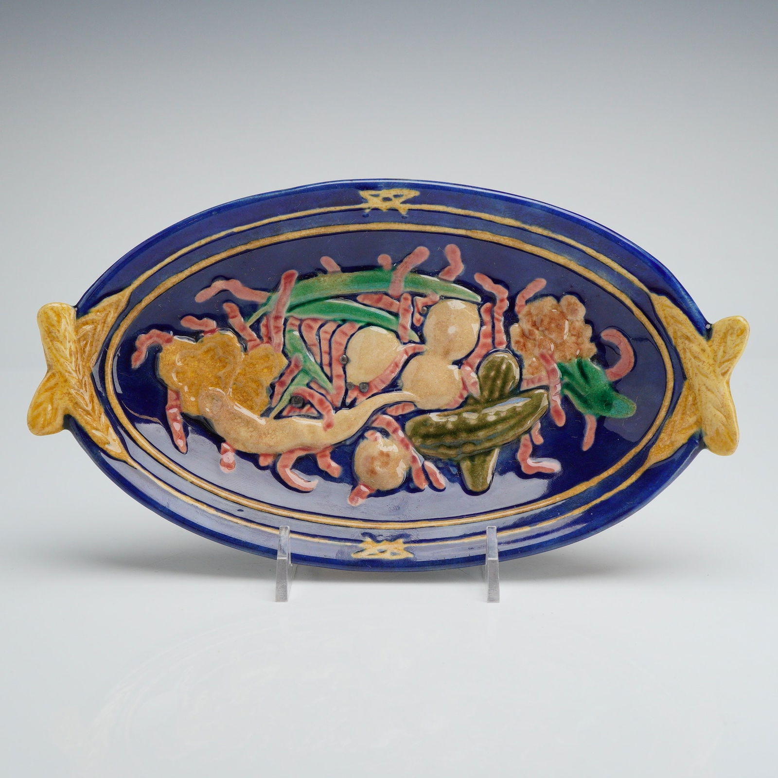 Wedgwood Majolica Pickles & Vegetable Oval Serving Dish: A fine Wedgwood Majolica Pickles & Vegetable Oval Serving Dish, dating to the 1870s. The ceramic body features high-relief molded decoration with a vibrant cobalt blue lead-glazed interior. The centra