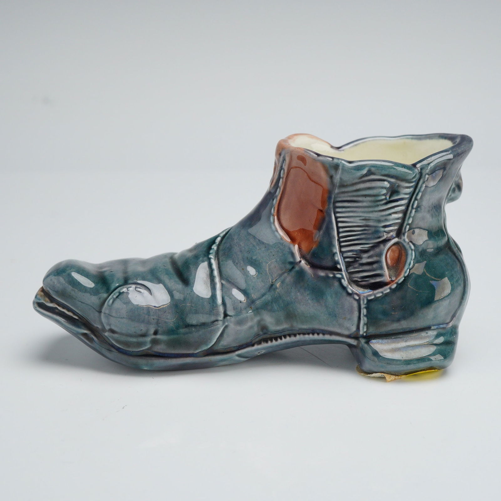 Wedgwood Novelty Glazed Boot Toothpick Holder: This novelty ceramic figural boot, likely intended as a spill vase or toothpick holder, is modeled in the form of a worn Chelsea-style work boot. The piece features intricate molded details, including