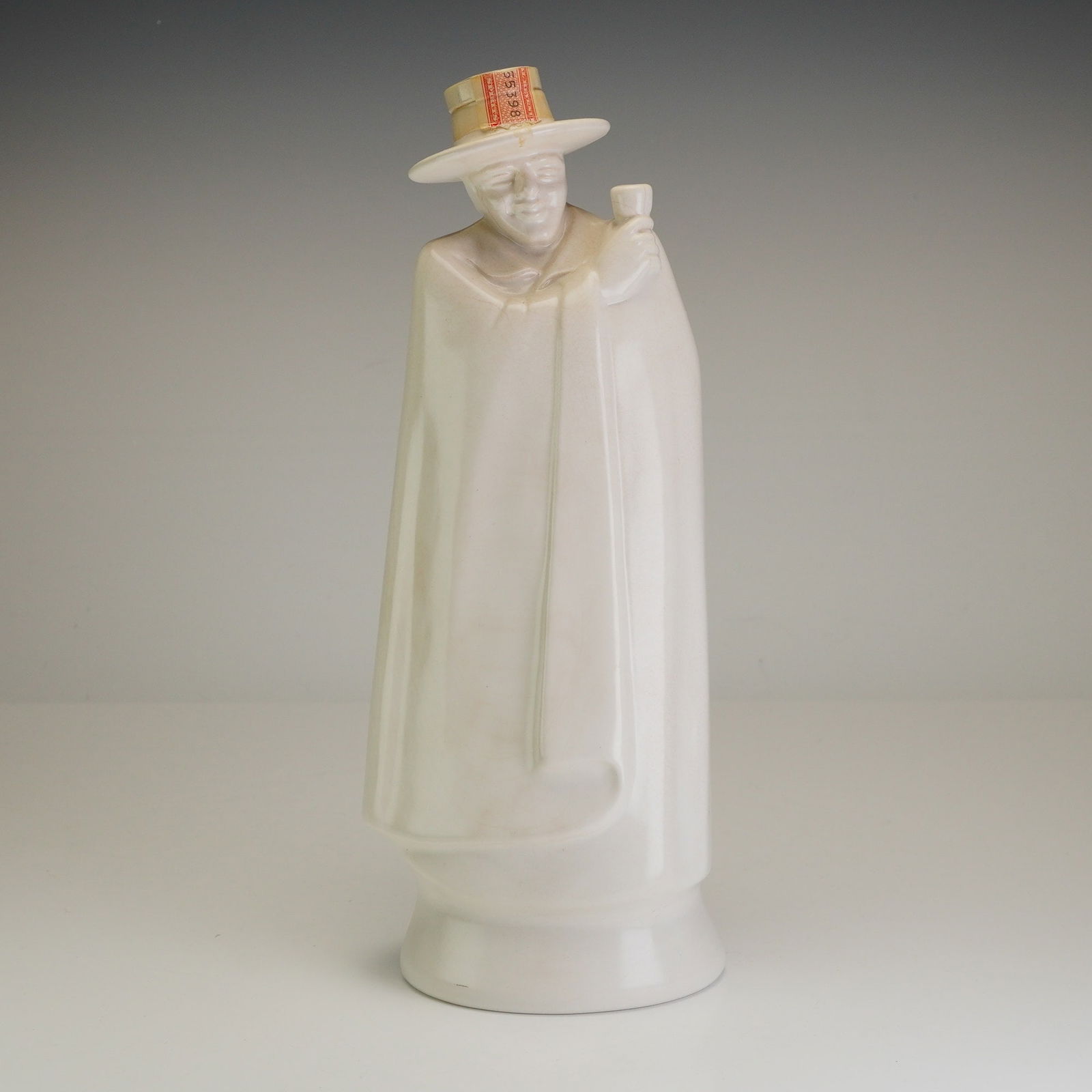 Wedgwood & Barlaston Etruria White Moonstone Decanter, The Don: This vintage figural decanter was produced by Wedgwood of Etruria and Barlaston, England, for Geo. G. Sandeman Sons and Co., Ltd. The piece is crafted from glazed ceramic featuring the signature matte