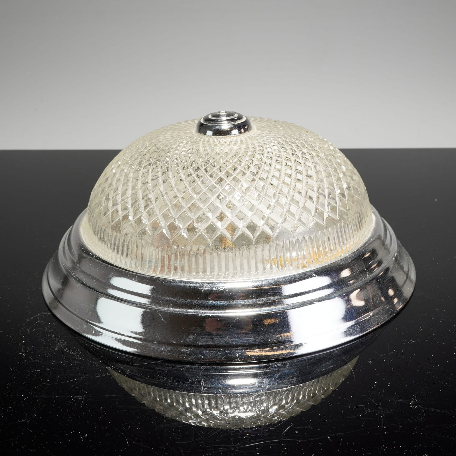 Mid-Century Modern Pressed Glass and Aluminum Flush-Mount Ceiling Light Fixture: Features a polished aluminum base and matching tiered finial. The fixture is equipped with a domed pressed glass shade featuring a repeating diamond-cut geometric pattern and a fluted border, a design