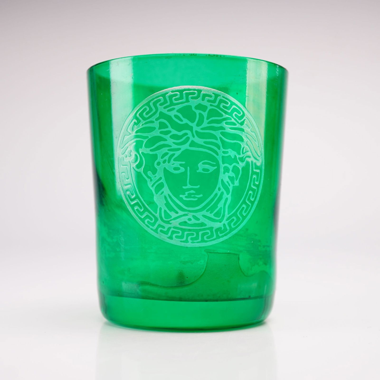 Rosenthal for Versace, Etched Medusa Emerald Green Glass Votive Candle Holder: This contemporary art glass votive candle holder is a collaborative creation between the German manufacturer Rosenthal and the Italian luxury house Versace. Rendered in a vibrant transparent emerald g