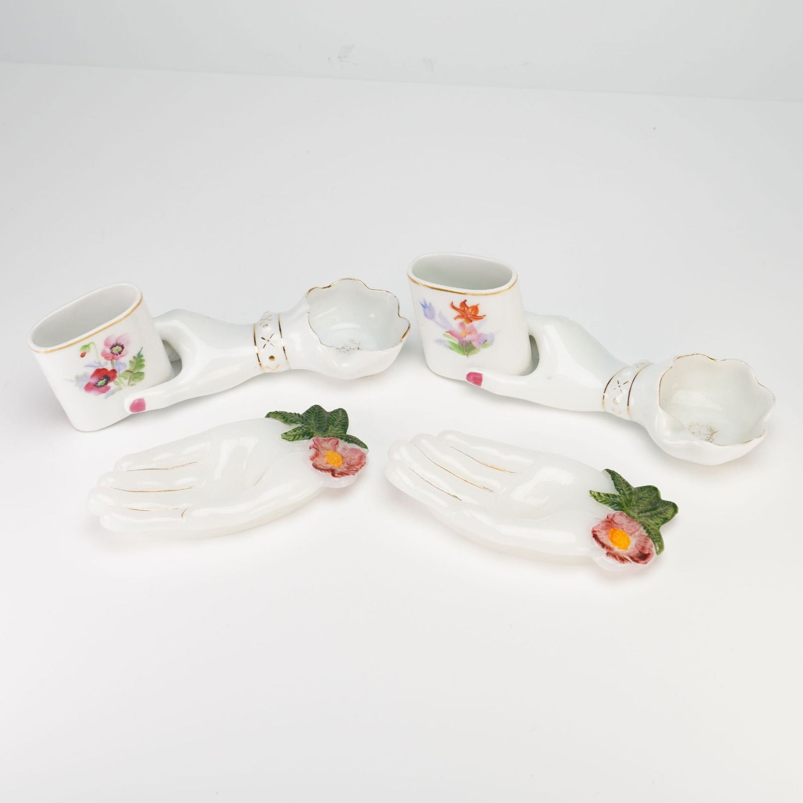 Japanese Porcelain and Milk Glass Hand-Form Ashtrays and Cigarette Holders: This four-piece collection of vintage Japanese decorative items features elegant figural hand-form designs. The set includes a pair of porcelain hand-painted cigarette holders and ashtrays, each depic