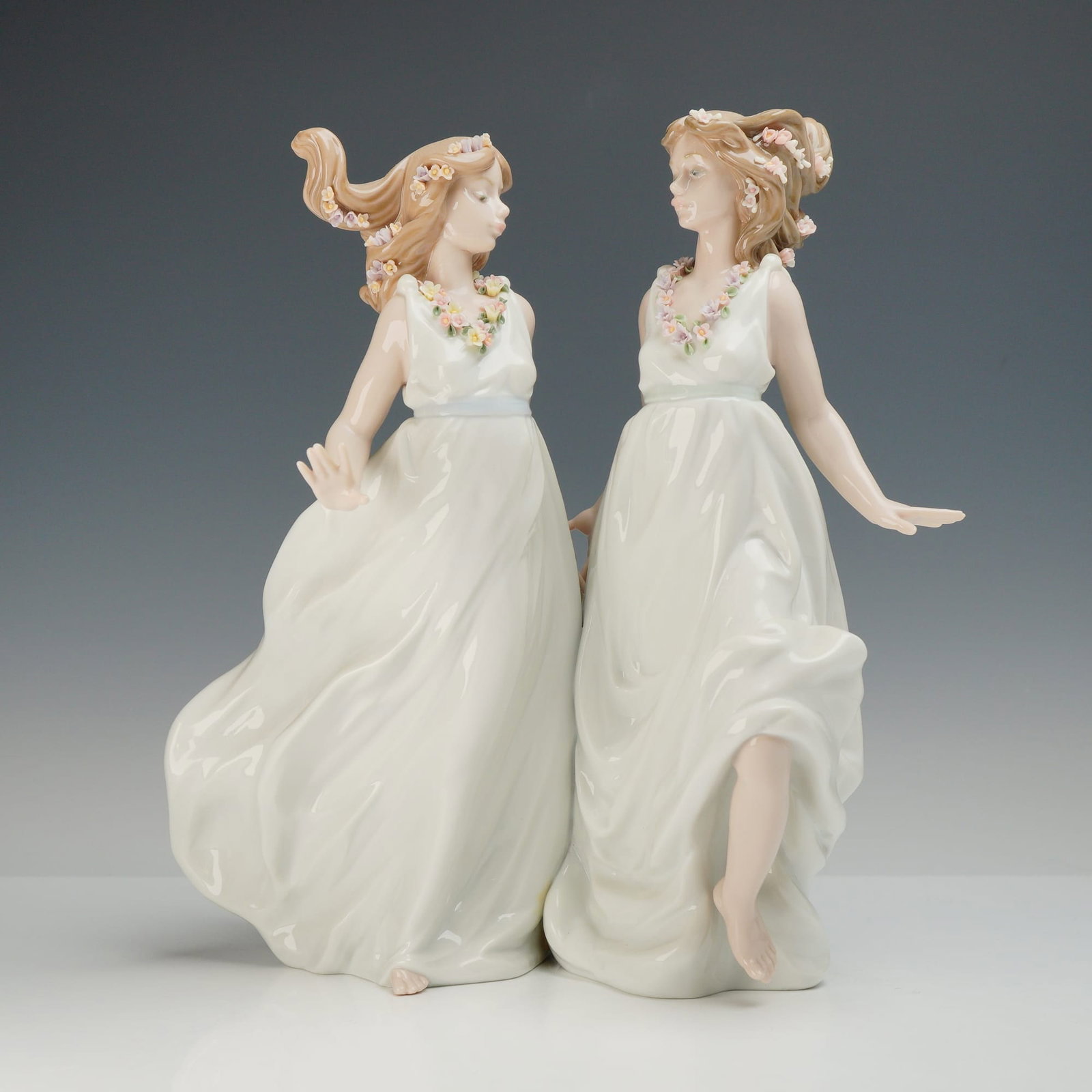 Lladro Allegory of Spring Porcelain Figurine 6241: This Lladro glazed porcelain figurine group is identified as Allegory of Spring, model number 6241. The large-scale piece depicts two young women in flowing white gowns, captured in a dynamic pose wit