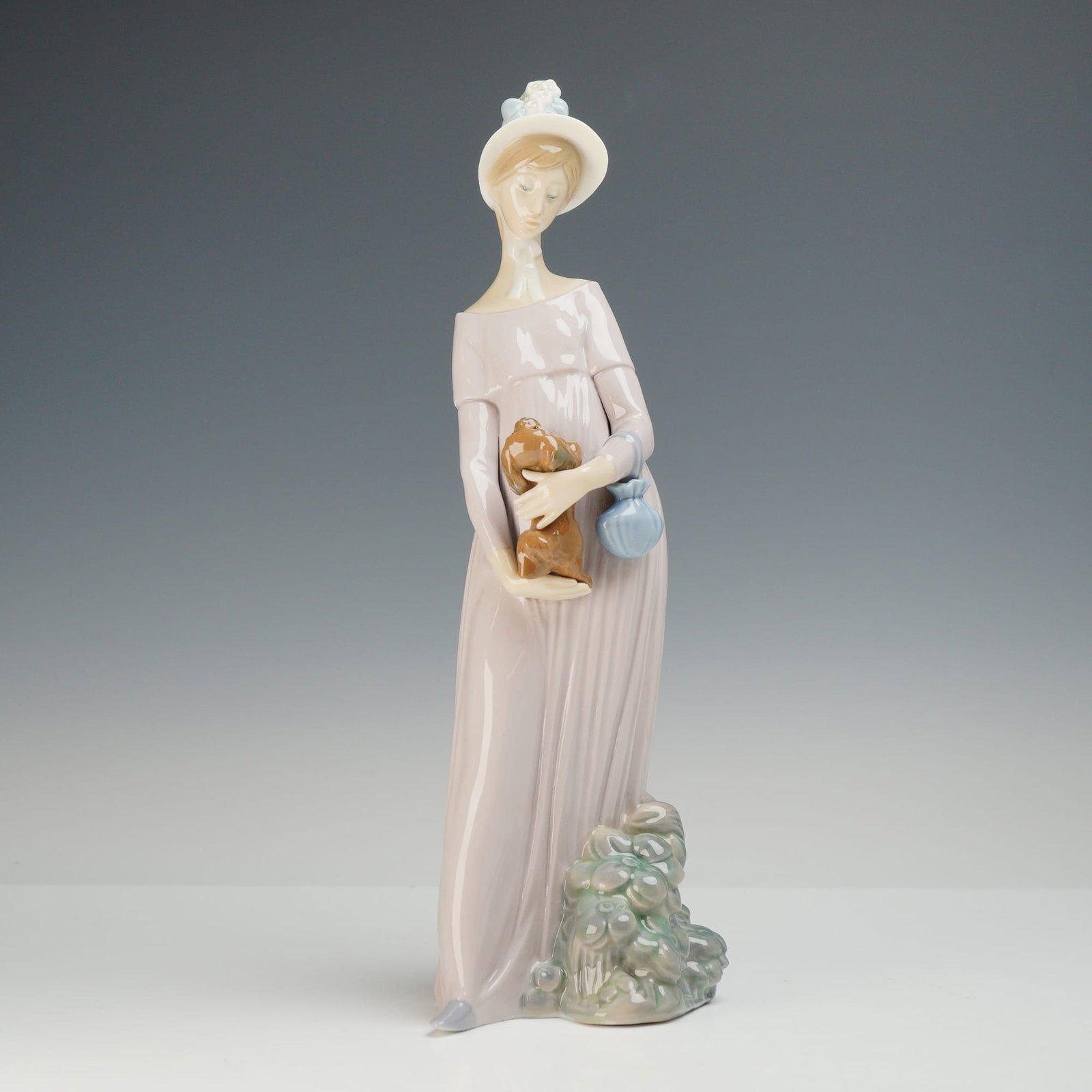 Lladro My Little Pet Porcelain Figurine Model 4994: This Lladro glazed porcelain figurine is model number 4994, titled My Little Pet and also known as Girl Looking at Her Dog. Designed by sculptor Vicente Martinez, the piece features a tall, slender yo