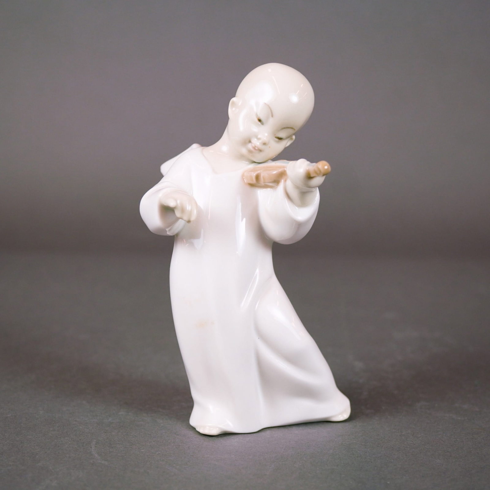 Lladro Porcelain Figurine, Angel Boy Playing Violin (Model 01004536): A vintage Lladro porcelain figurine, model number 01004536, titled "Angel Boy Playing Violin." This retired piece, produced between 1971 and 1974, depicts a stylized young boy in long, flowing robes c