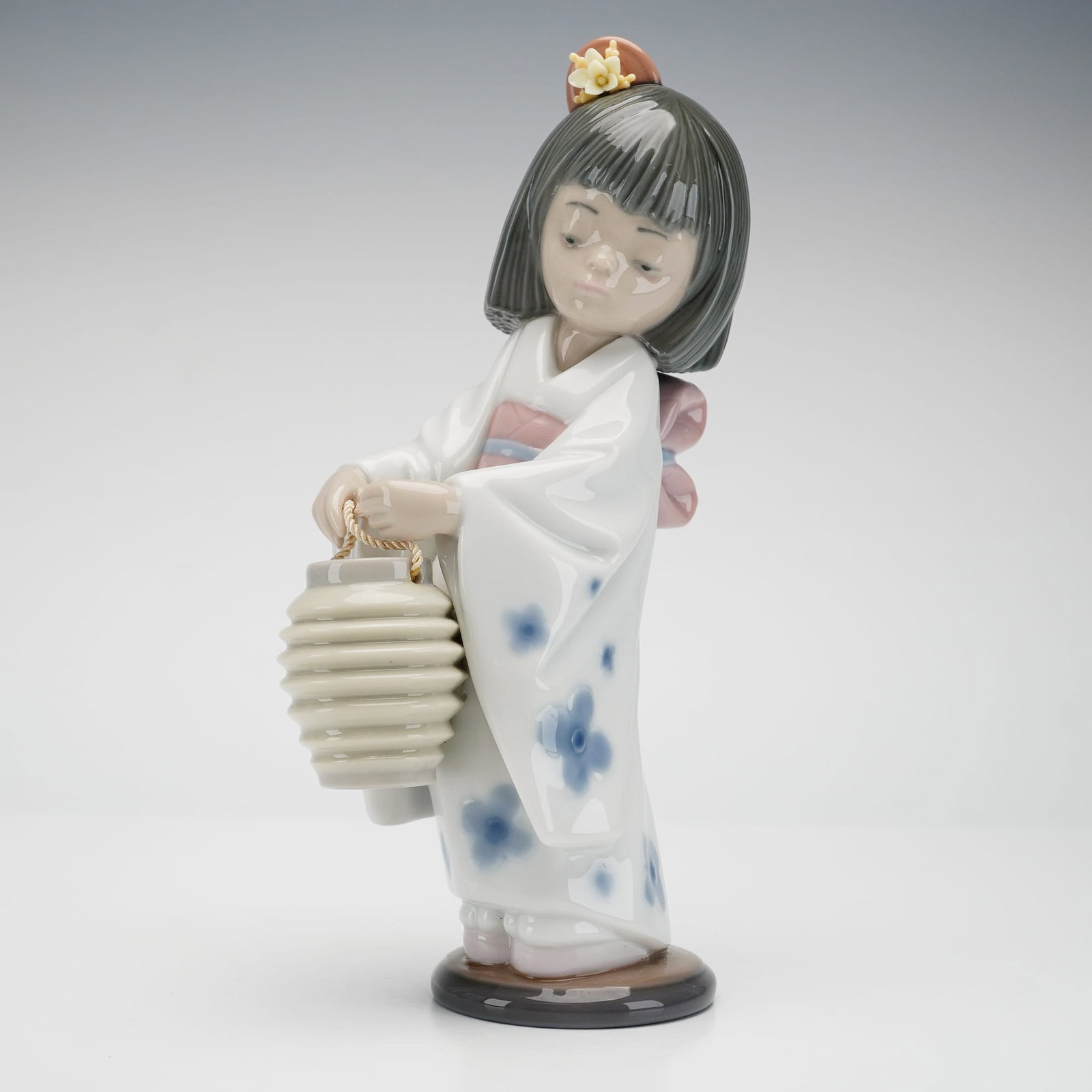 Lladro Porcelain Figurine, Oriental Lantern Girl #01006201: A fine Lladro high-gloss glazed porcelain figurine titled Oriental Lantern (also known as Japanese Girl with Lantern), model number 6231 and reference number 01006201. The piece depicts a young girl i
