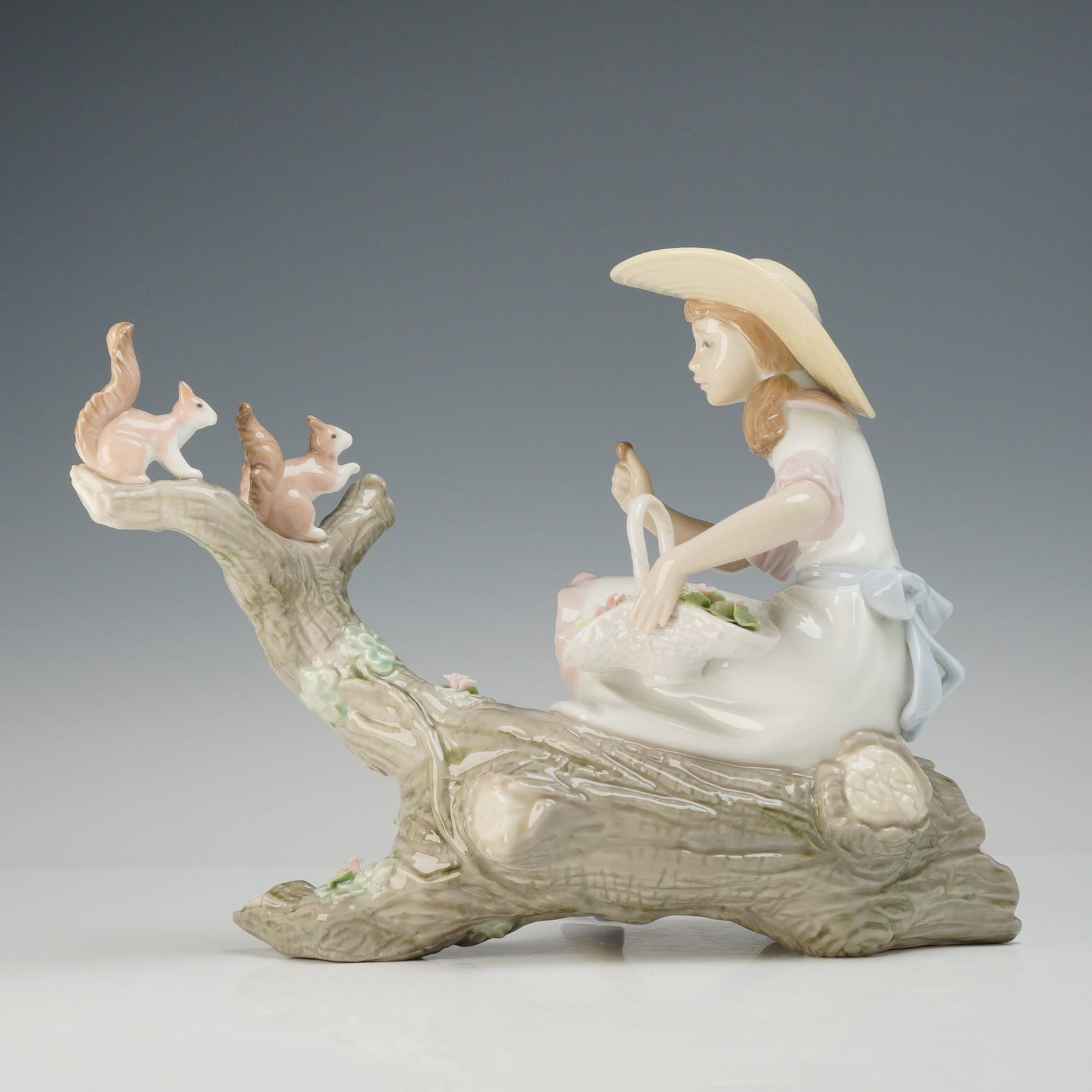 Lladro Springtime Friend Porcelain Figurine 6140: This Lladro porcelain figurine, identified by web consensus as Springtime Friend (model 6140), is crafted from glazed porcelain. The piece depicts a young girl seated on a gnarled gray tree log. She i