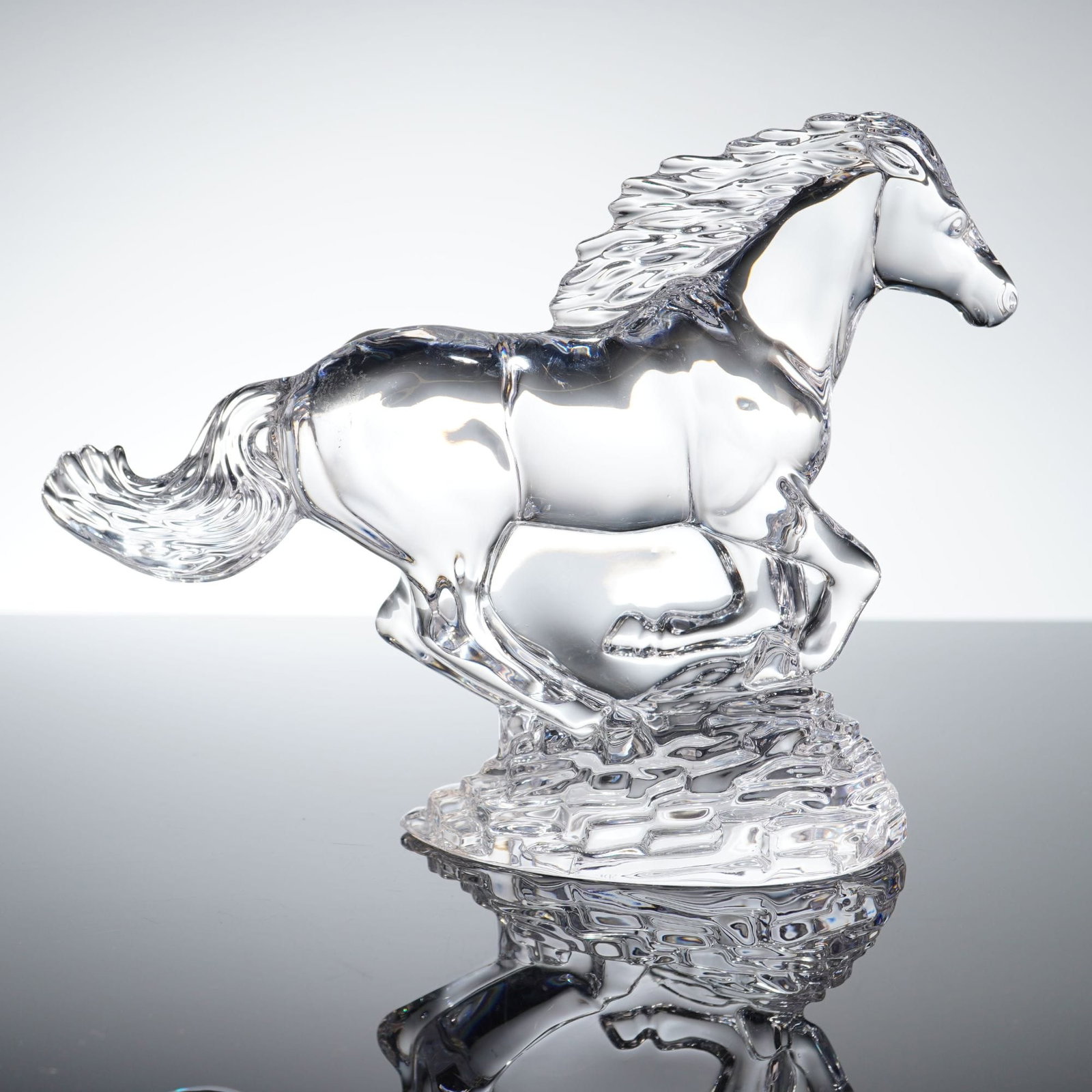 Waterford Crystal Running Horse Sculpture: Waterford Crystal Running Horse Sculpture, model number 40034828. This lead crystal figurine depicts a horse in a dynamic galloping pose with a flowing mane and tail. The figure is mounted on an integ